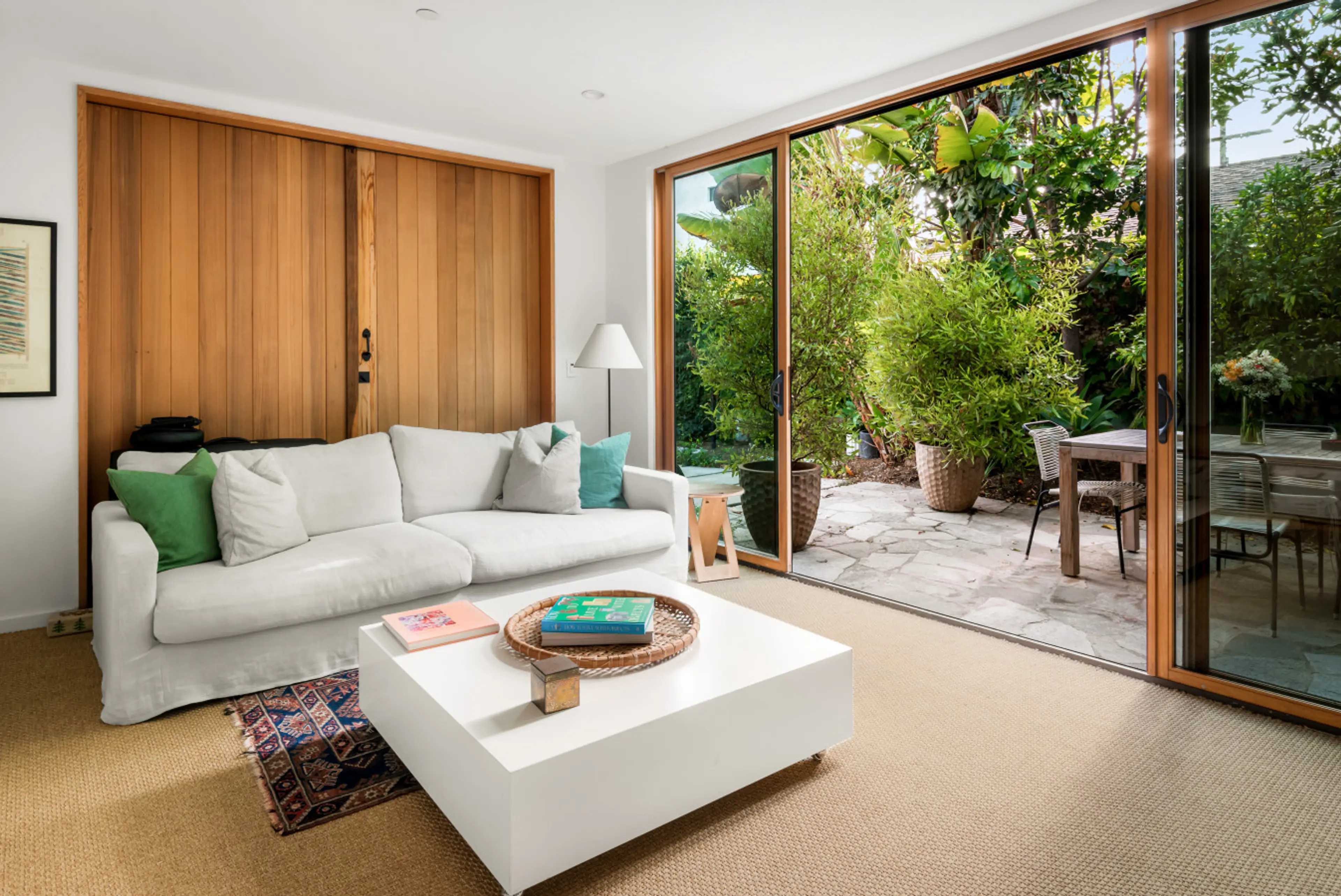 Relax in the living room while enjoying a refreshing view of lush greenery outside.