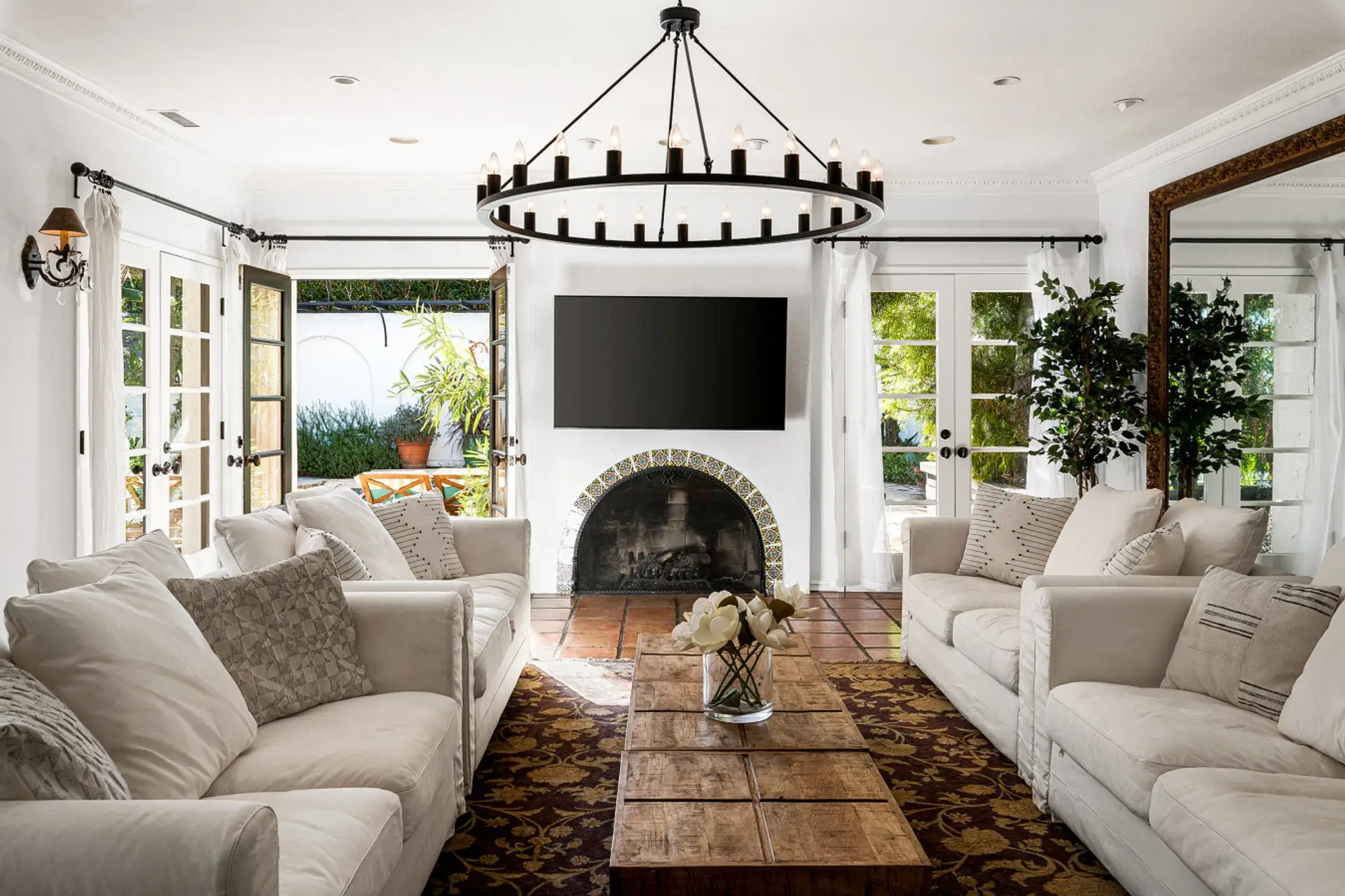 Relax in a bright, elegant living room where Spanish charm meets modern comfort, complete with cozy seating and seamless indoor-outdoor flow.
