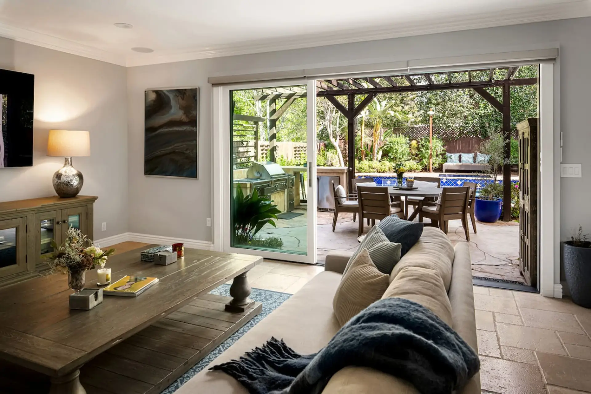 Step into relaxation—this living room opens effortlessly to a sunlit patio and sparkling pool.