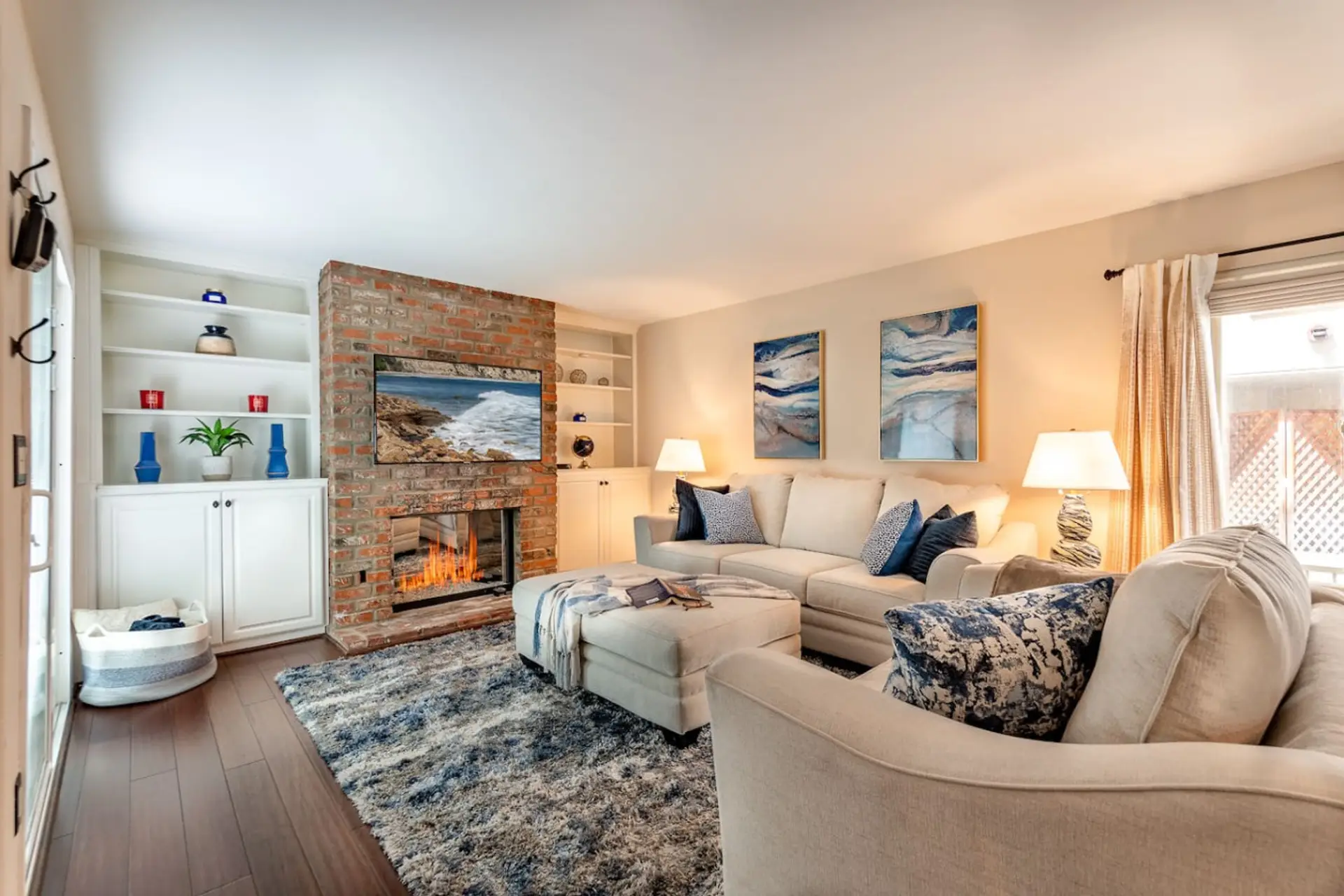 Sink into the plush sectional sofa and cozy up by the exposed brick fireplace — this warm, beautifully decorated living room is perfect for relaxing evenings with great company.