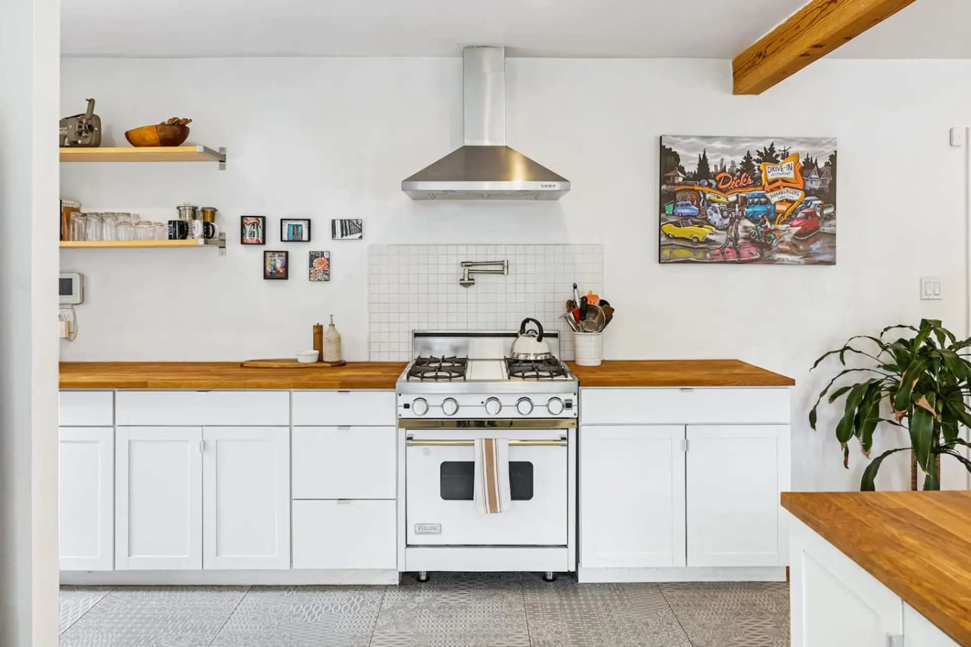 Fully equipped chef's kitchen with a professional-grade range, butcher block counters, and sleek white cabinetry