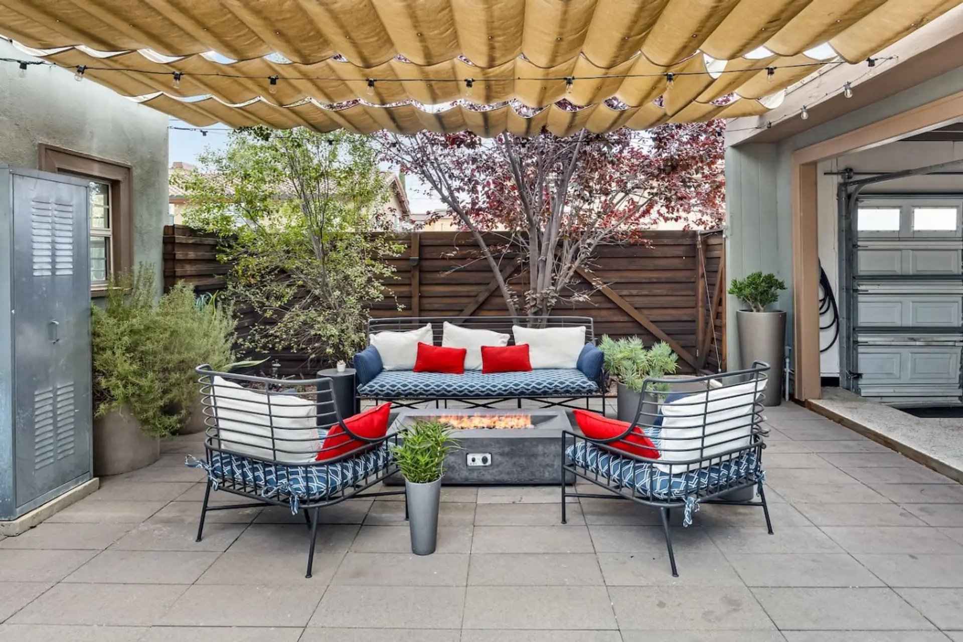 Shaded patio with cozy lounge seating and lush greenery — perfect for morning coffee or evening gatherings