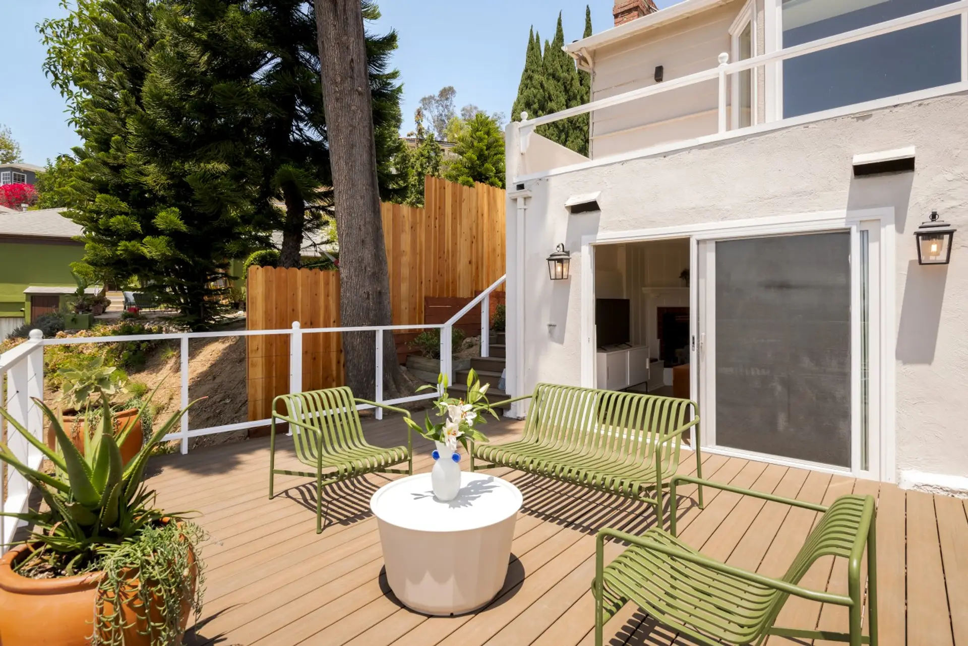 Private deck with seating, surrounded by greenery — the perfect spot to unwind outdoors.