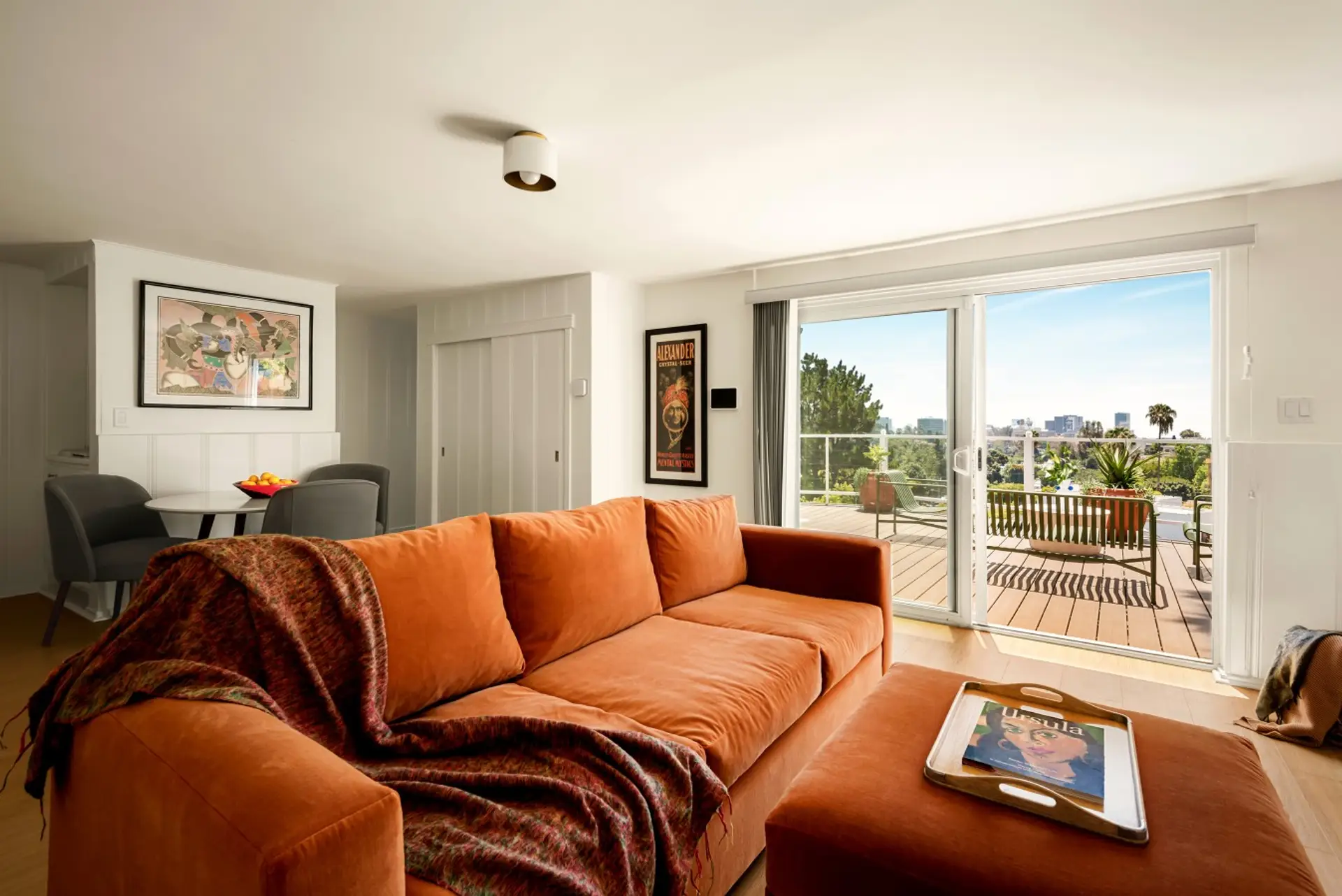Bright living room with plush seating and direct access to the deck and city views.