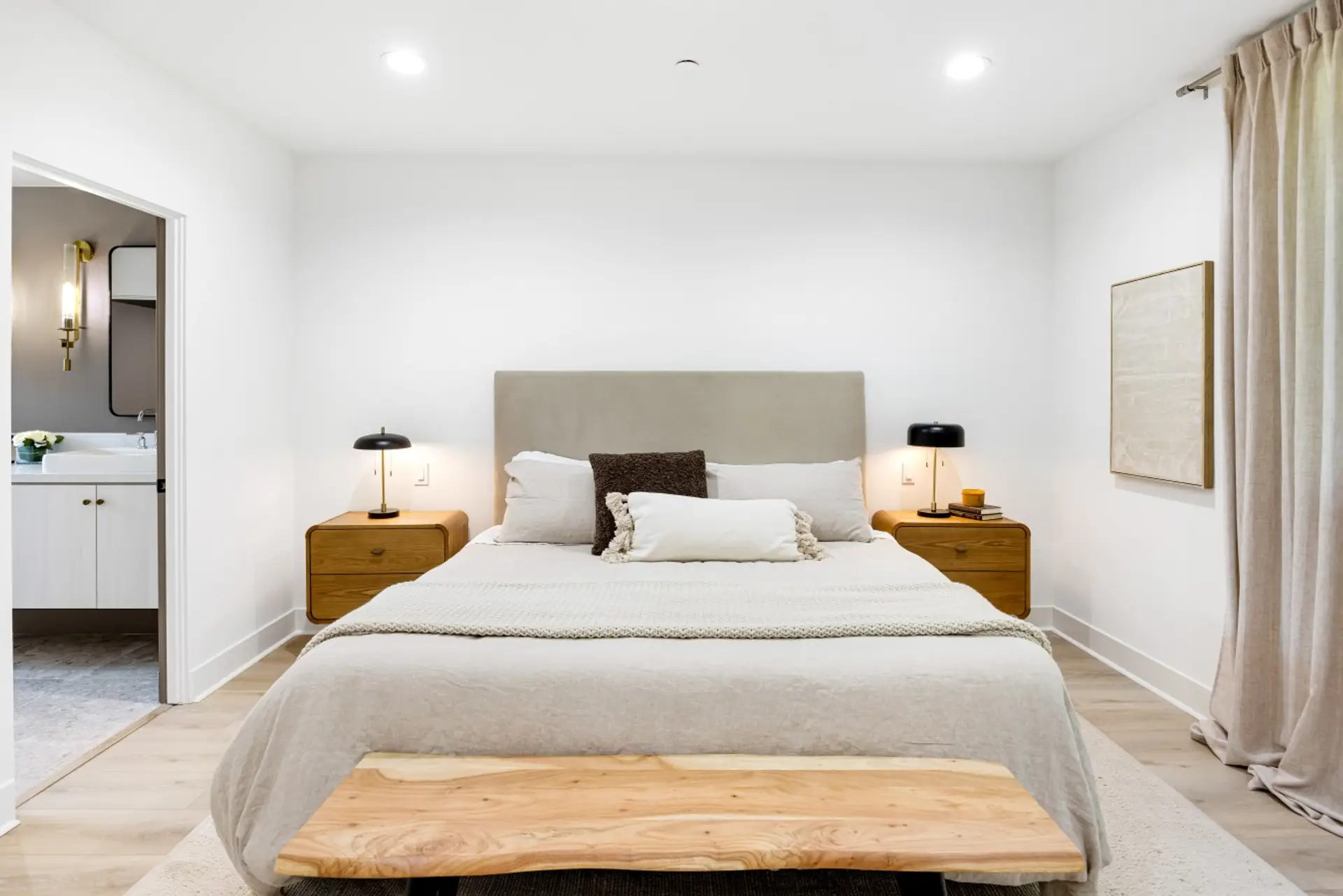 A calm, neutral-toned bedroom with a plush upholstered headboard, perfect for a restful night's sleep.