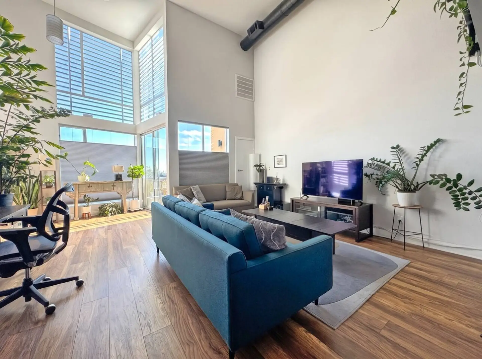 Sunlight pours through floor-to-ceiling windows onto a living room made for unwinding after a day exploring the city.