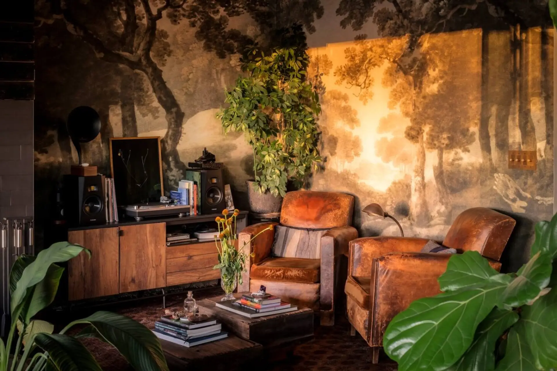A double-height living room wrapped in a hand-painted mural, perfect for sinking into the leather chairs and unwinding.