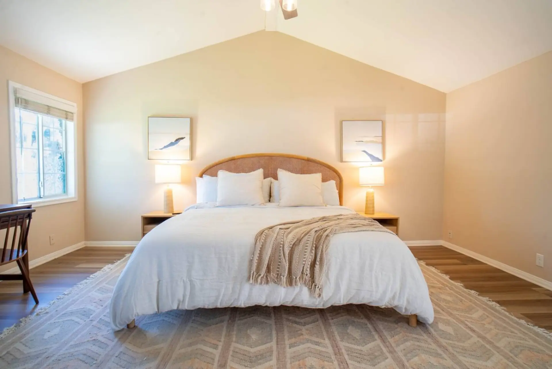 Spacious primary suite with a vaulted ceiling, king bed, and ceiling fan