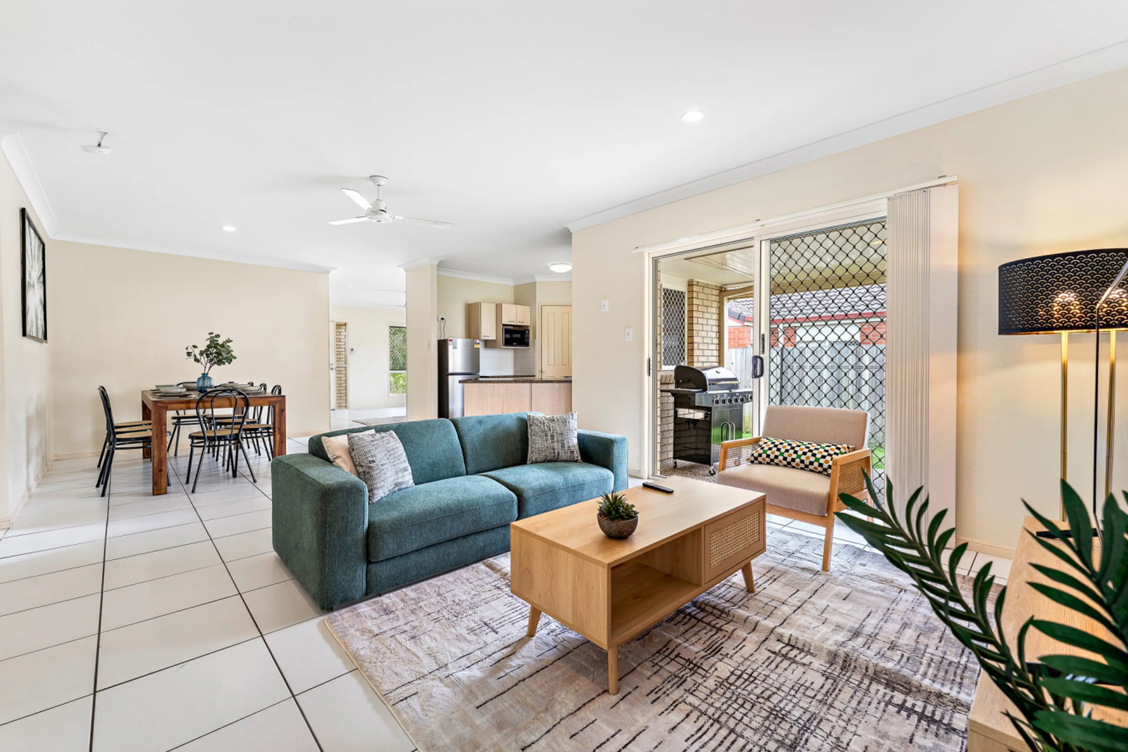 Step into a bright and stylish open-plan living space, thoughtfully designed for comfort and relaxation. The inviting lounge features a plush sofa, warm lighting, and tasteful décor, flowing effortlessly into the dining area and fully equipped kitchen.