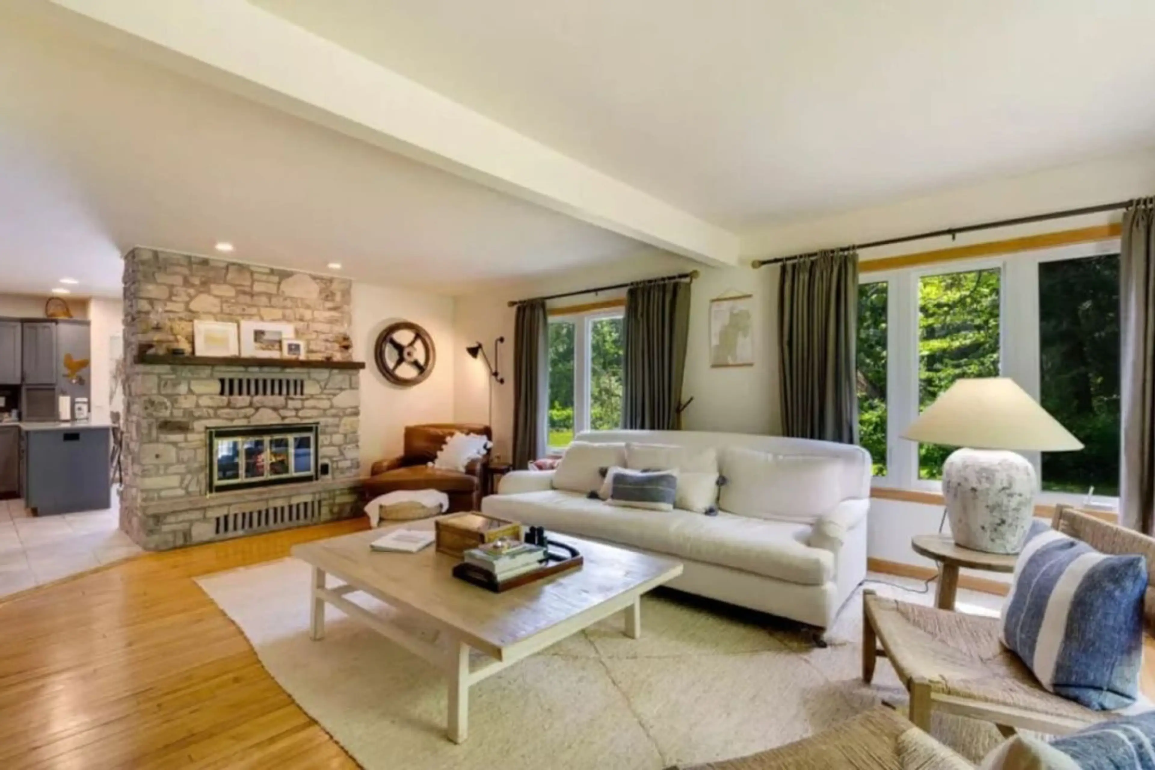 Living Room: Open, bright and inviting retreat with stunning stone fireplace and nature views!