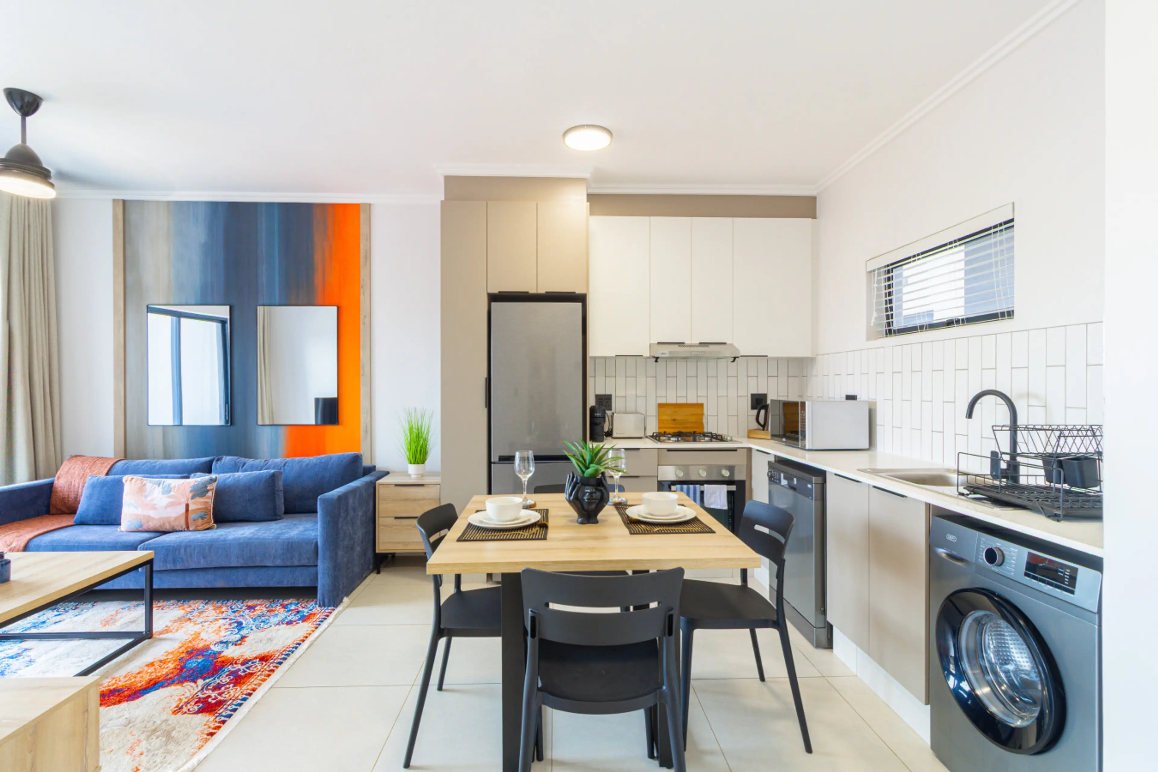 Bright open-plan lounge with comfy sofa and fully equipped kitchen