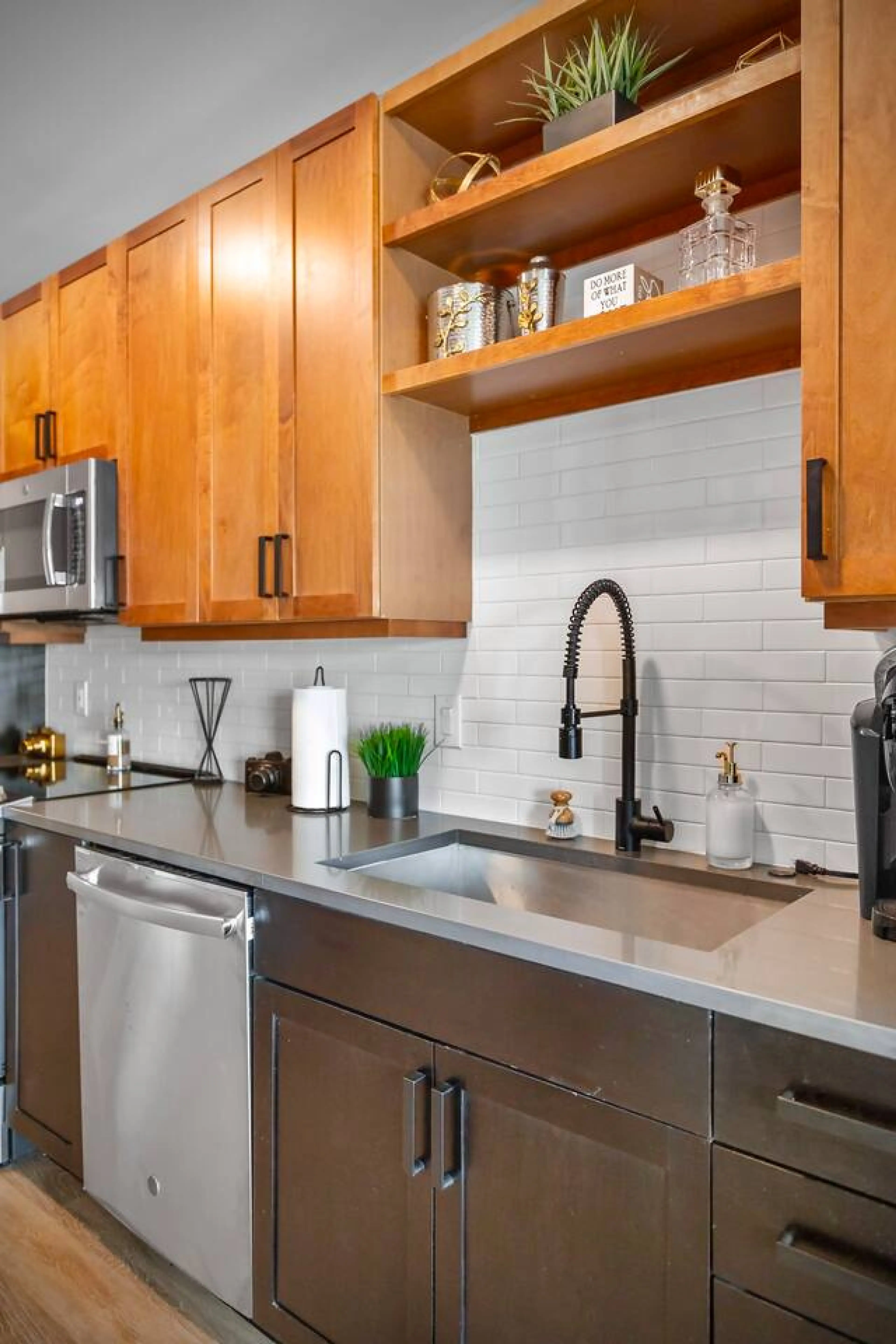 Cook with ease in a warm, modern kitchen featuring classic wood finishes paired with sleek stainless steel appliances