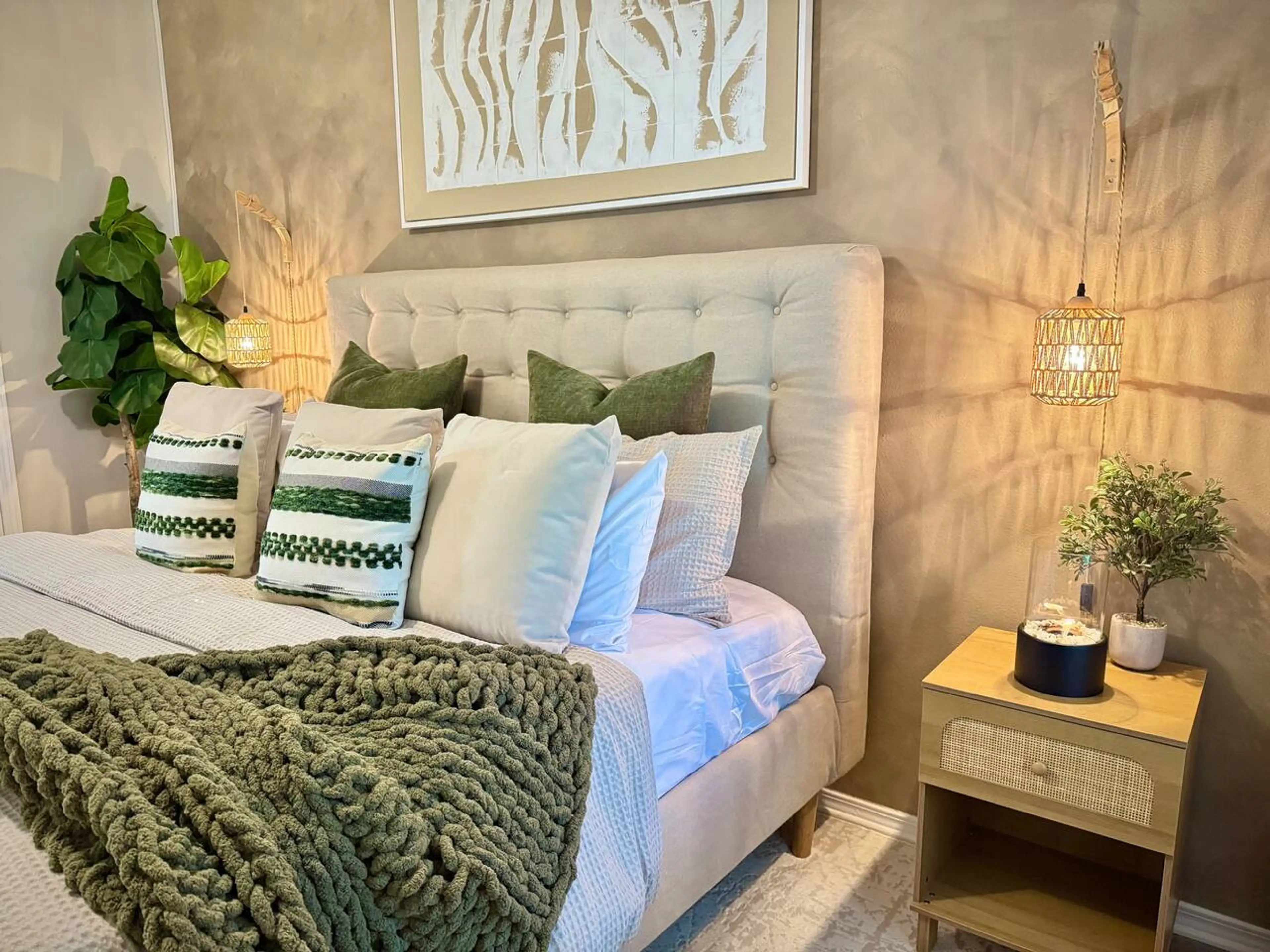 Wake up in calm — A king bed dressed in crisp whites, layered with soft nude tones and a pop of green.