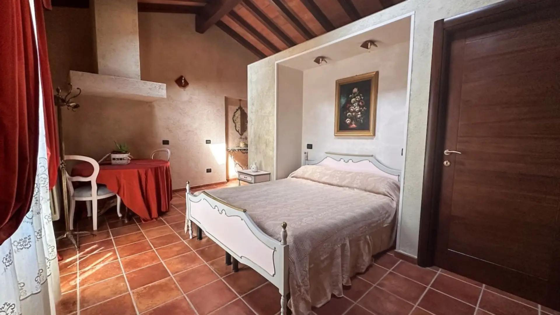 Ambiente accogliente con travi a vista e pavimenti in cotto. Un rifugio autentico nel cuore del borgo, completo di area relax e illuminazione soffusa.