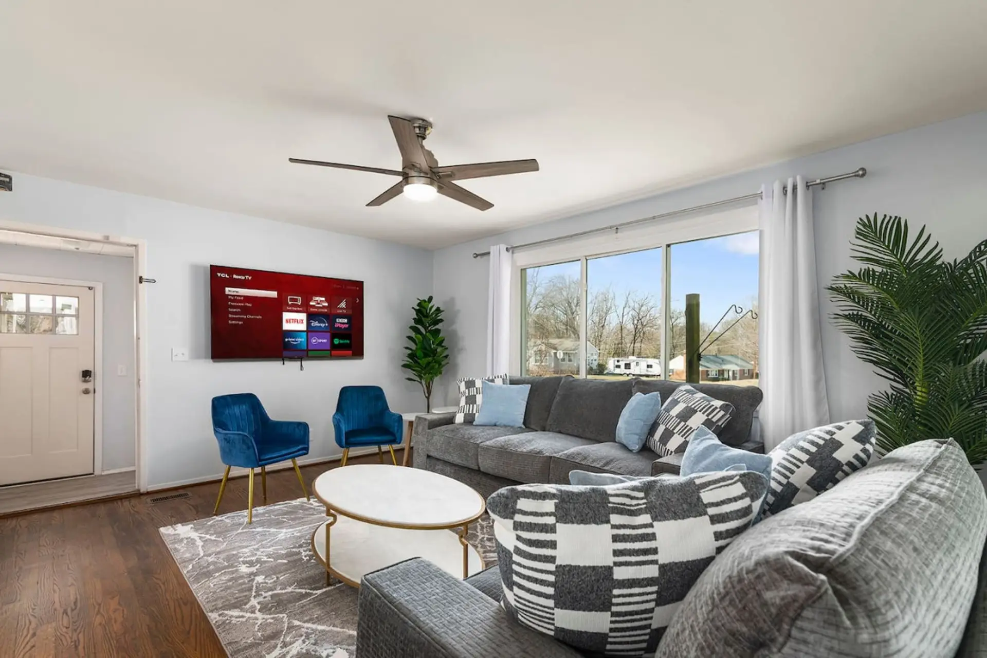living room, featuring a plush couch, a chic chair, and an smart TV