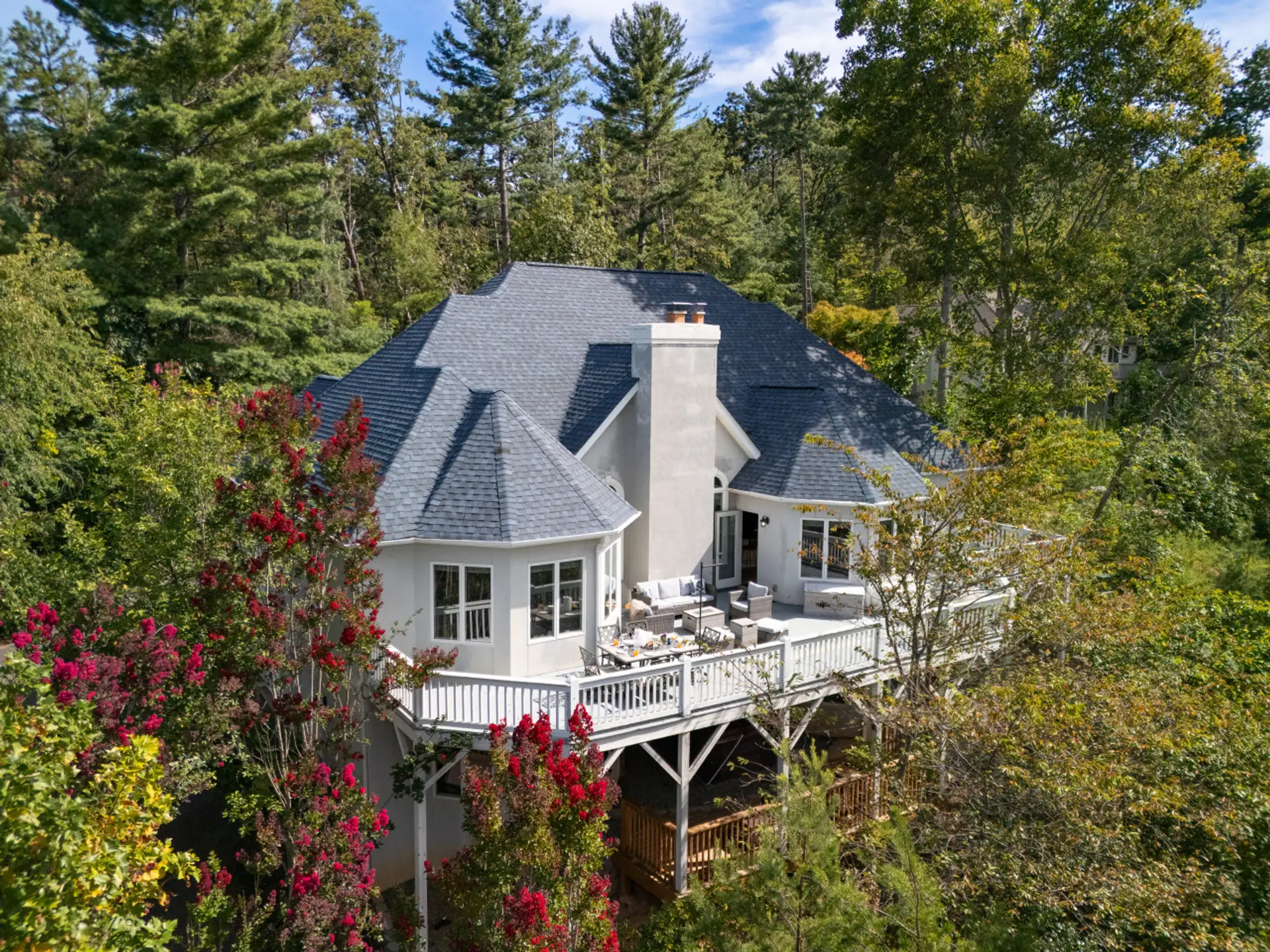 Aerial View | Beautiful home nestled in lush greenery with expansive deck and mountain views