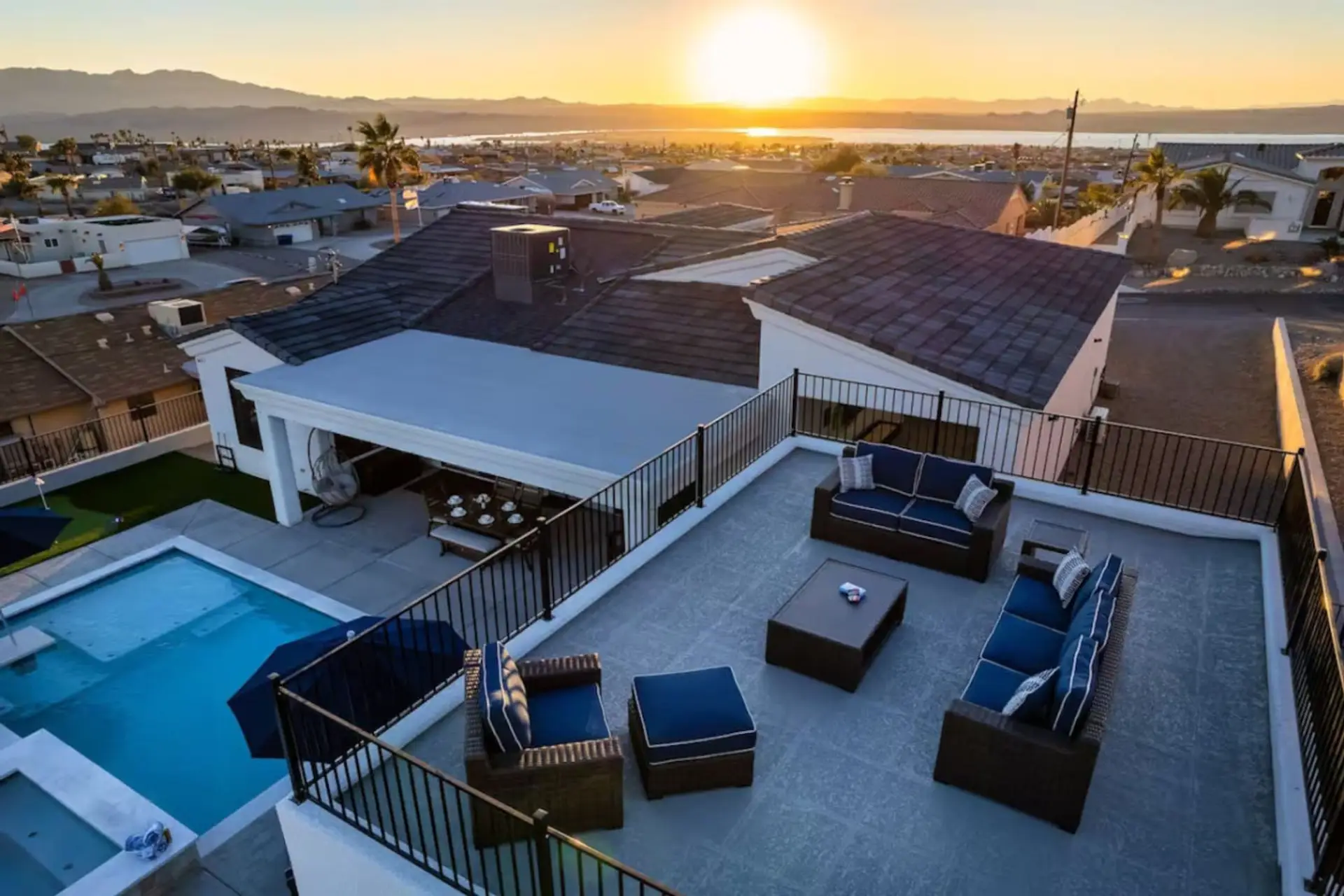 Rooftop deck with sectional seating, pool below & sweeping Lake Havasu sunset views — the best seat in the house