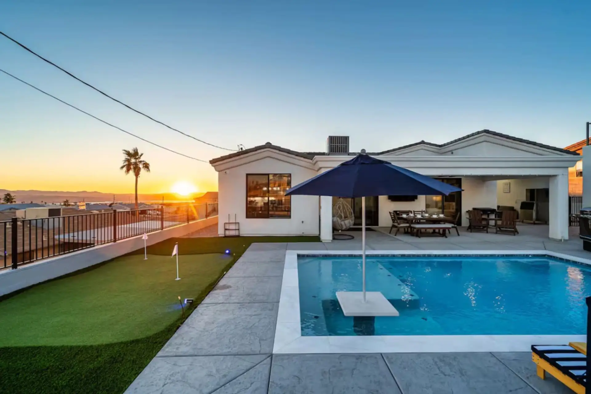 Sunset backyard with pool, putting green & outdoor dining — the shot guests screenshot before they book