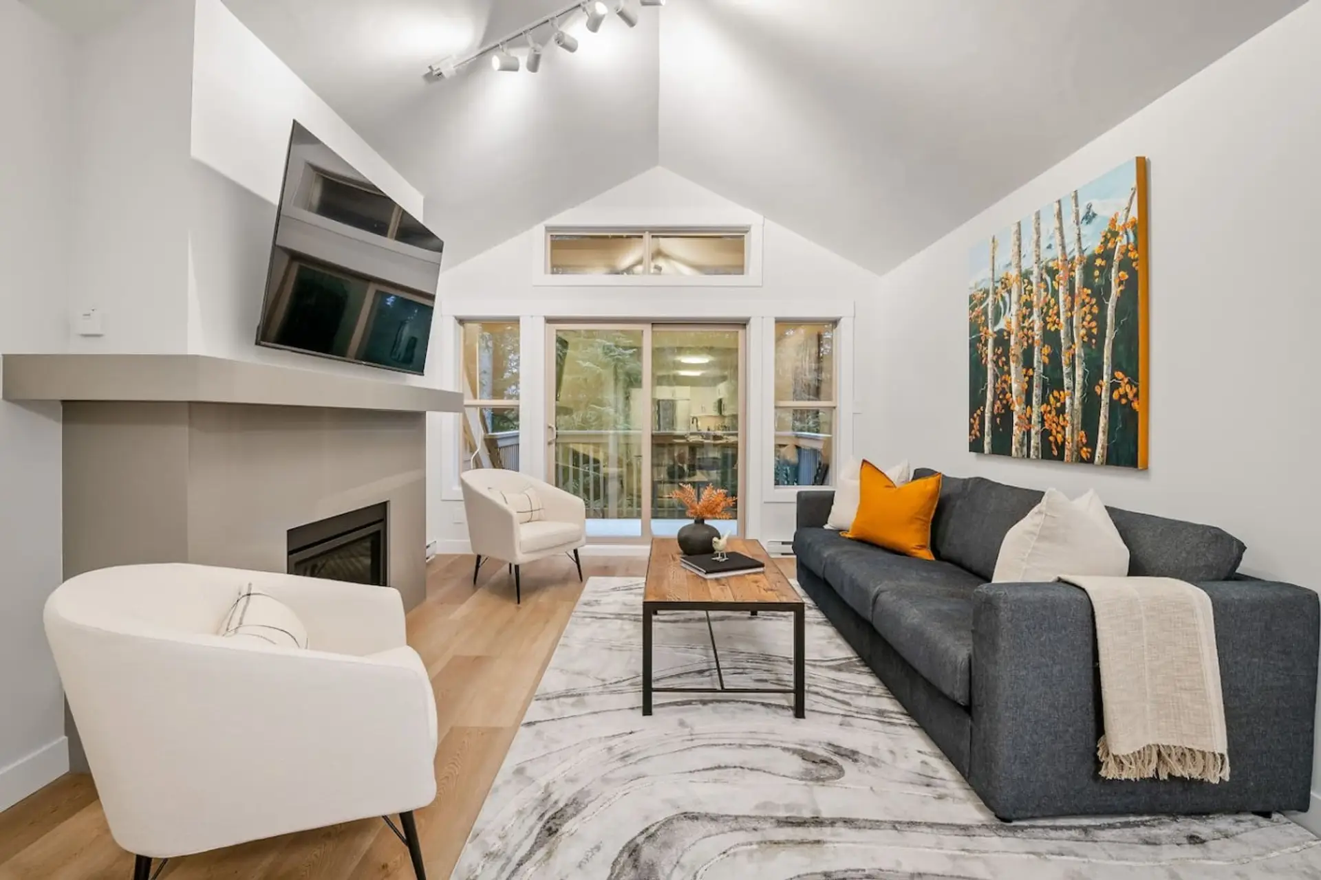 Spacious living area with fireplace, TV, private balcony.