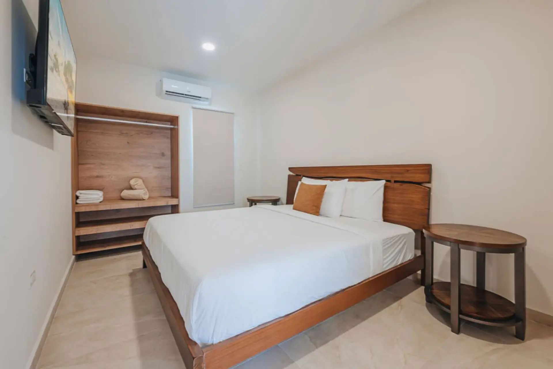 Find rest in your spacious bedroom with AC, storage shelving, a Smart TV, and side tables.