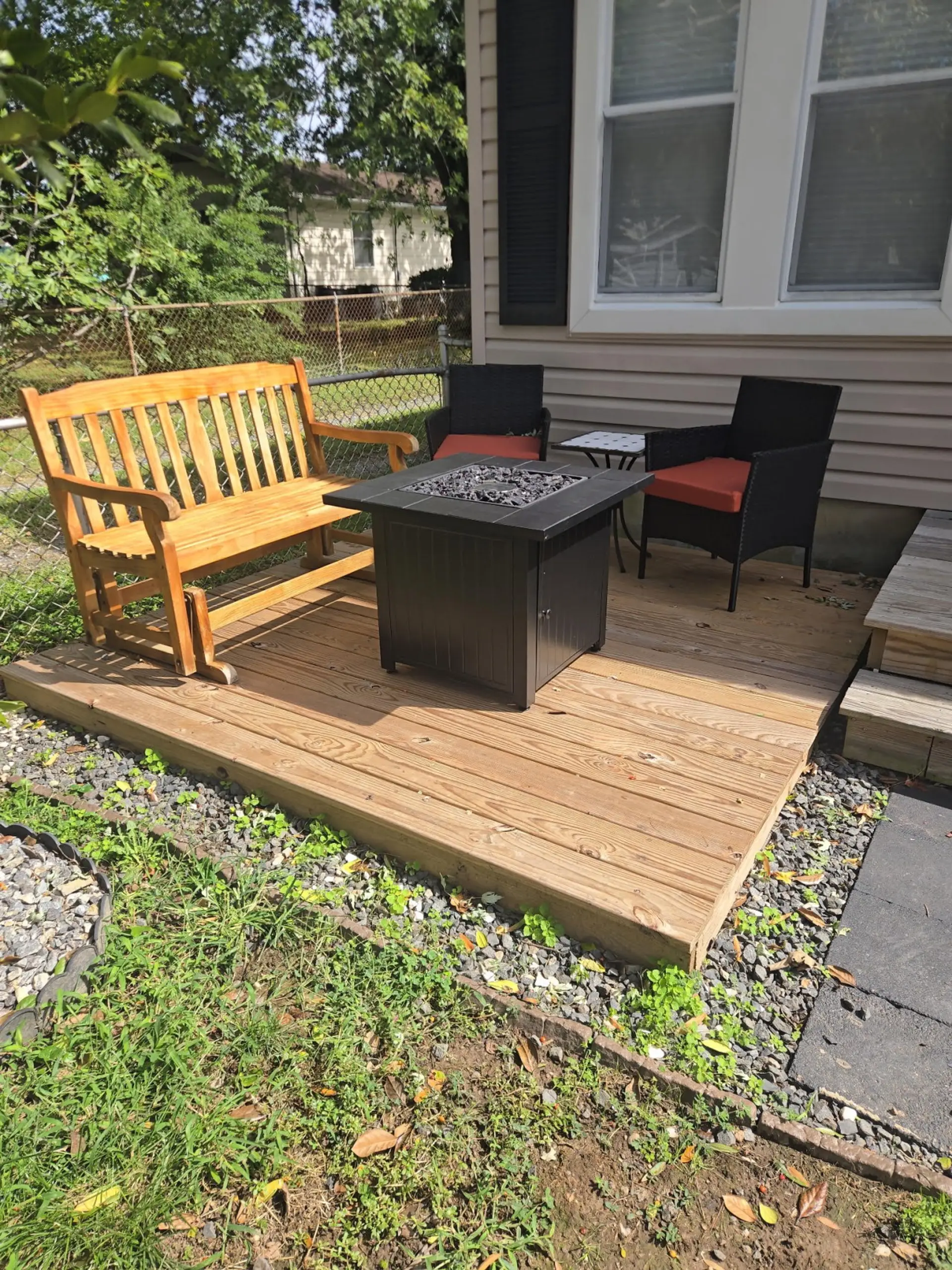 Outdoor deck with a fire pit table and seating for guests.