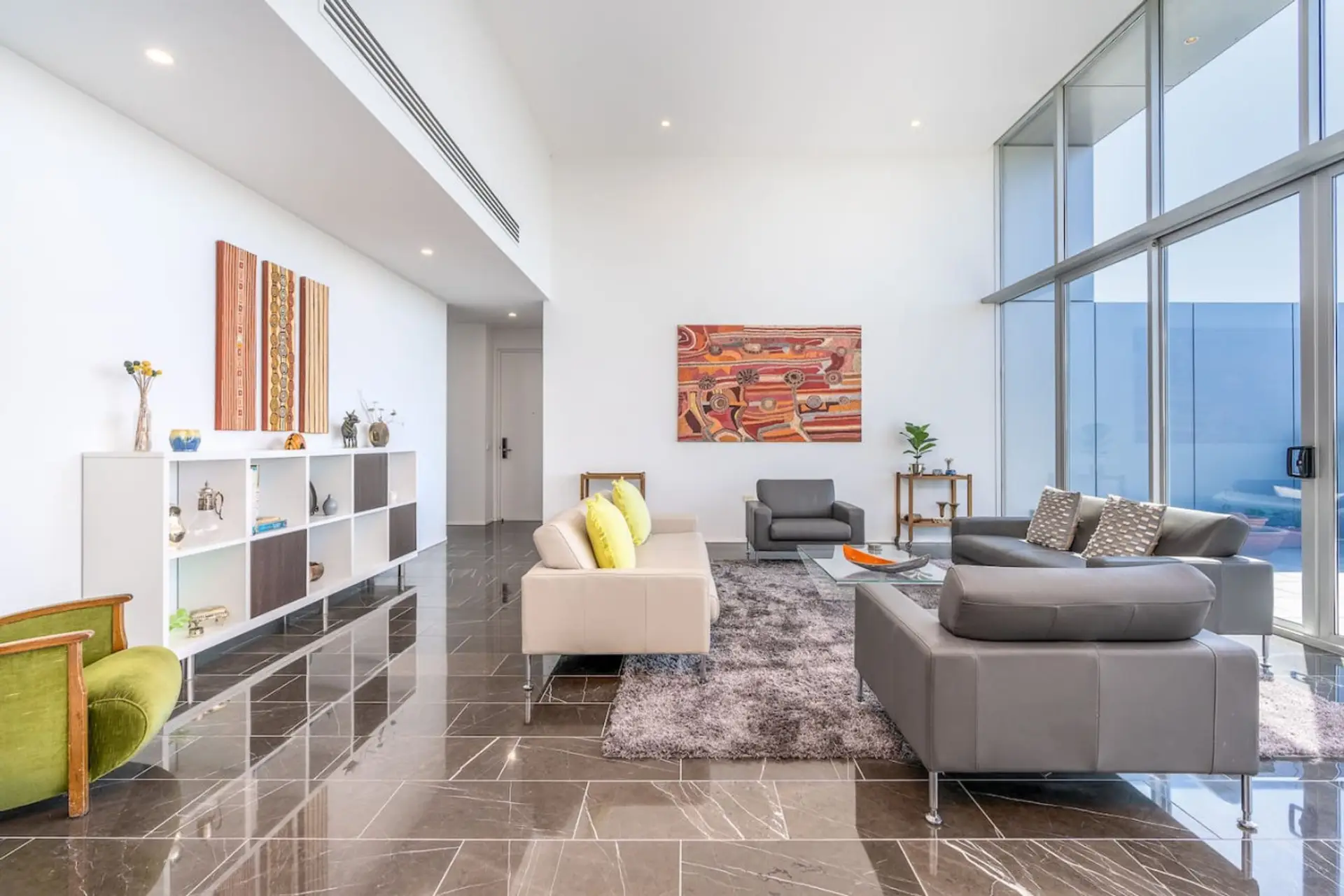 Relax in our spacious lounge room, featuring breathtaking penthouse views. The expansive layout and panoramic vistas create a luxurious and serene setting.