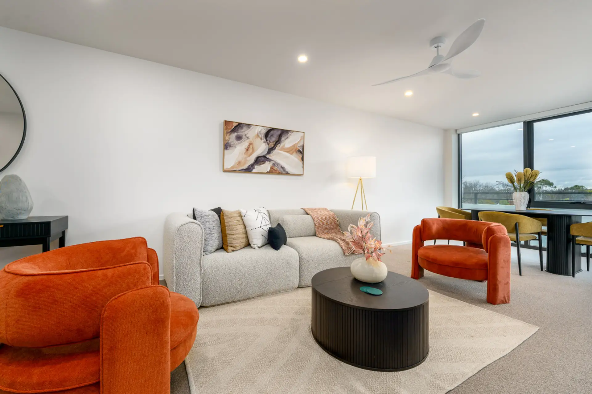 Warm and modern living space with bold accent chairs, soft textures, and plenty of natural light.