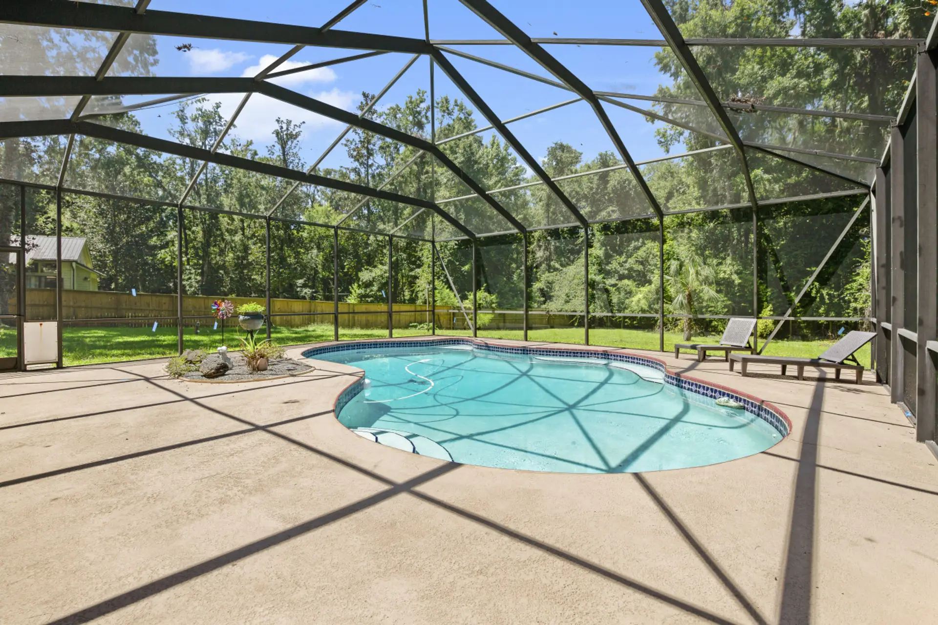 Large screen area with lounge chairs and pool