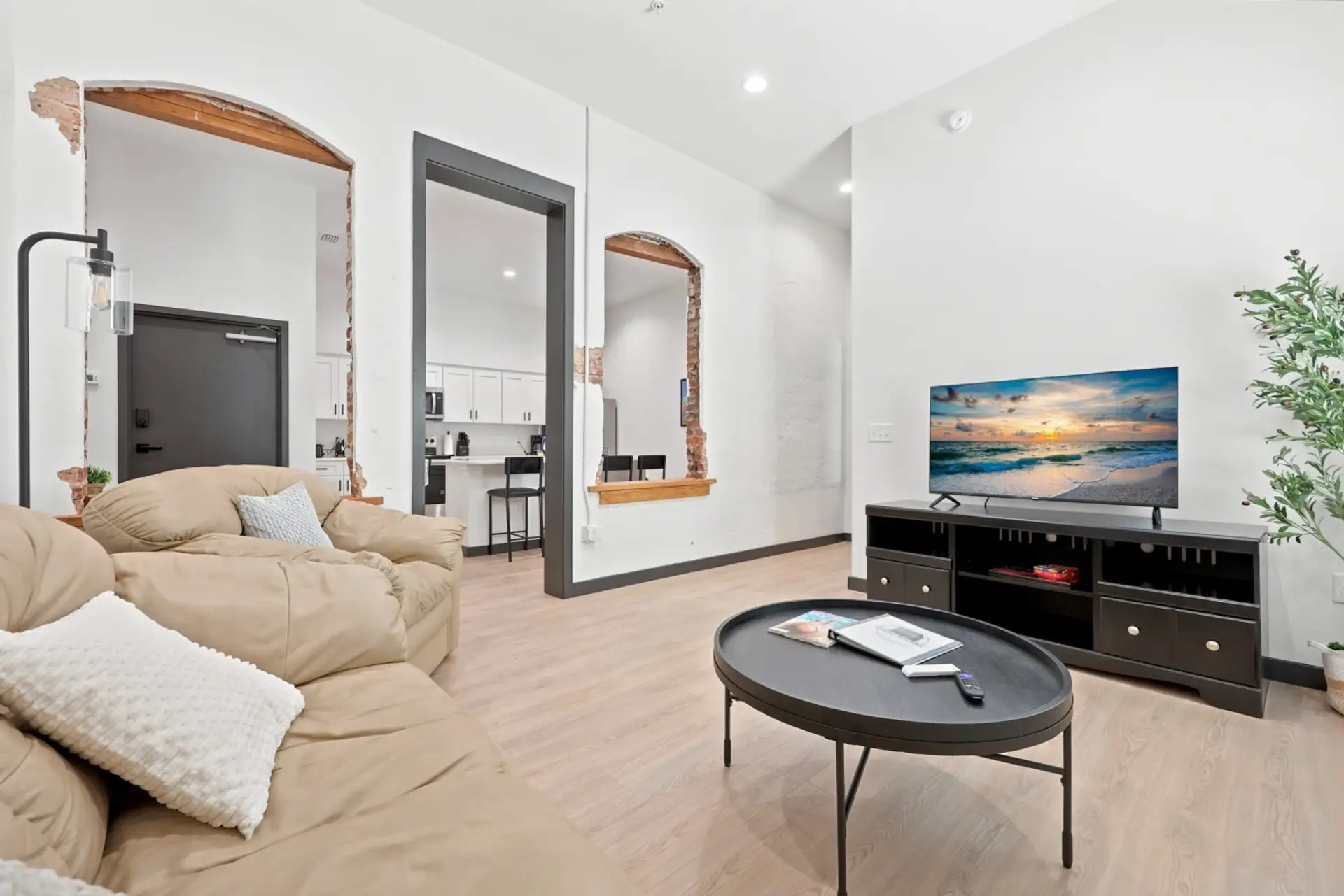 Living Room: Bright, spacious living area with comfortable seating, large TV, high ceilings, and stylish modern finishes.