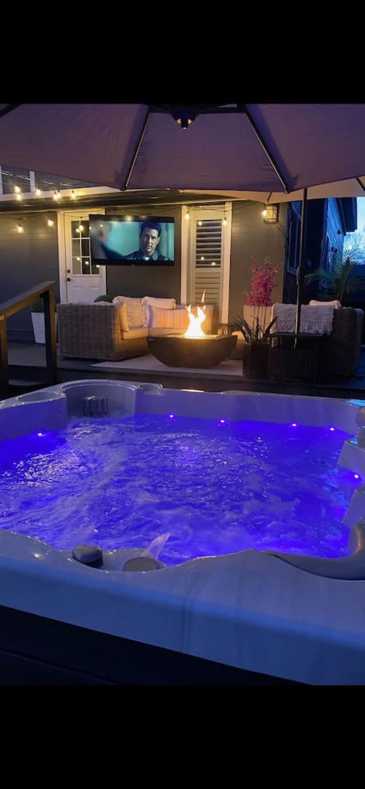 Backyard hot tub, deck, bicycles, and string lights