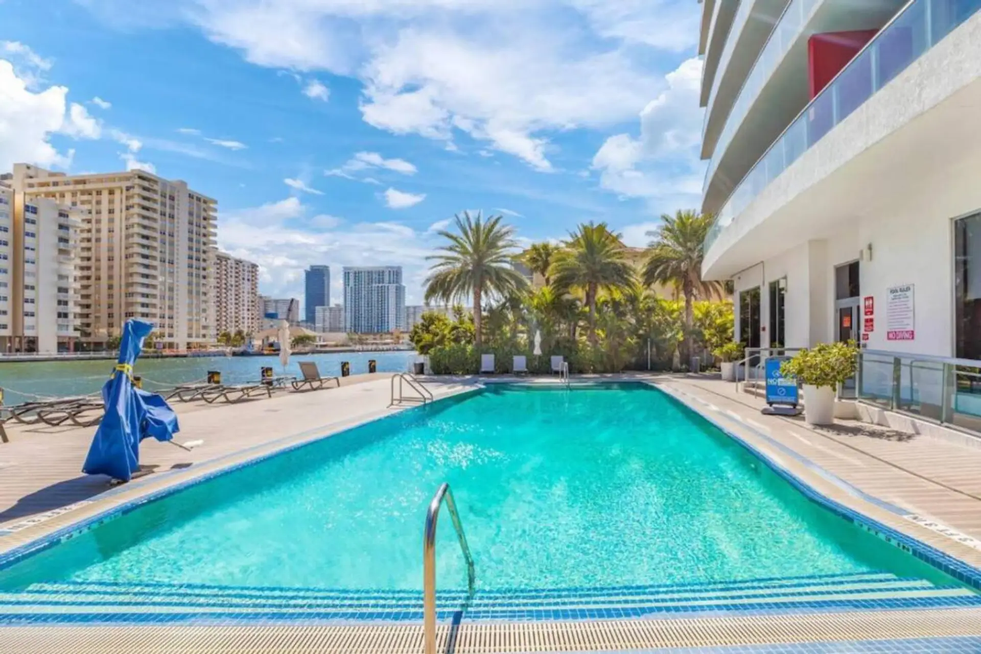 Outdoor pool surrounded by high-rises and cityscape views.