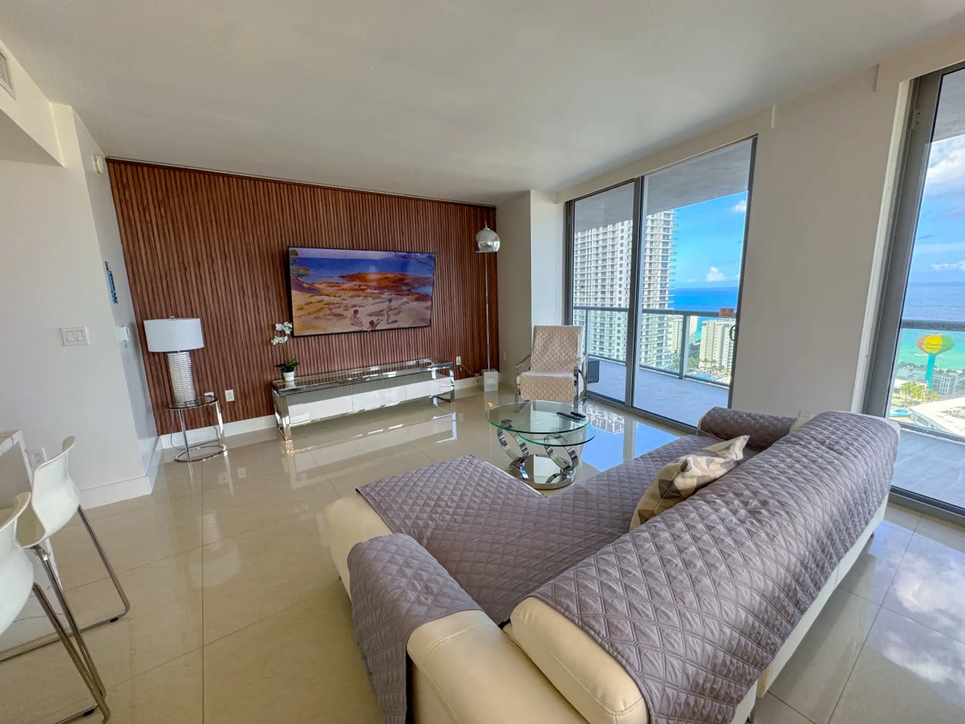 Bright living room with balcony access and city views.