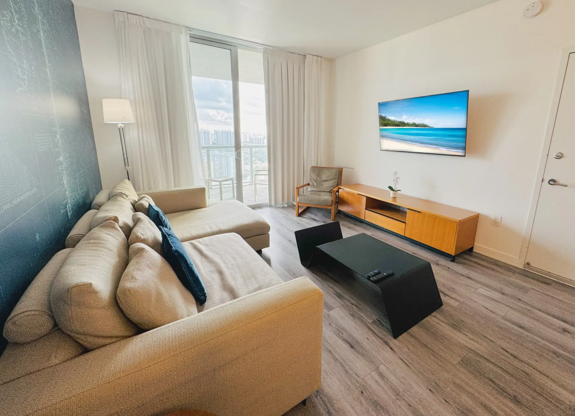 Bright living room with balcony access and city views.