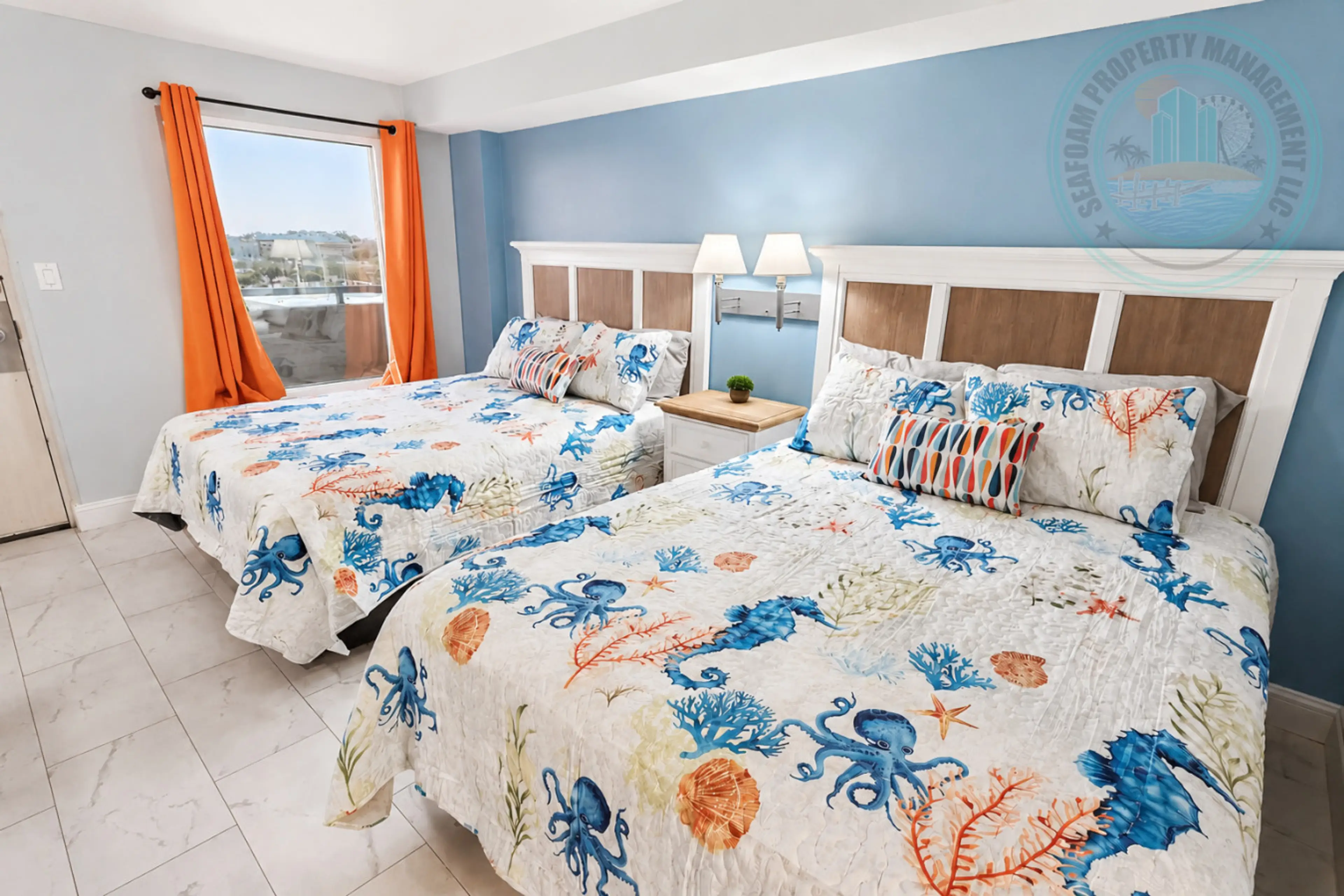 Bright coastal bedroom featuring two comfortable queen beds with beach-inspired décor and fresh, clean linens. Enjoy natural light, calming ocean tones, and a relaxing space perfect for unwinding after a day at the beach.