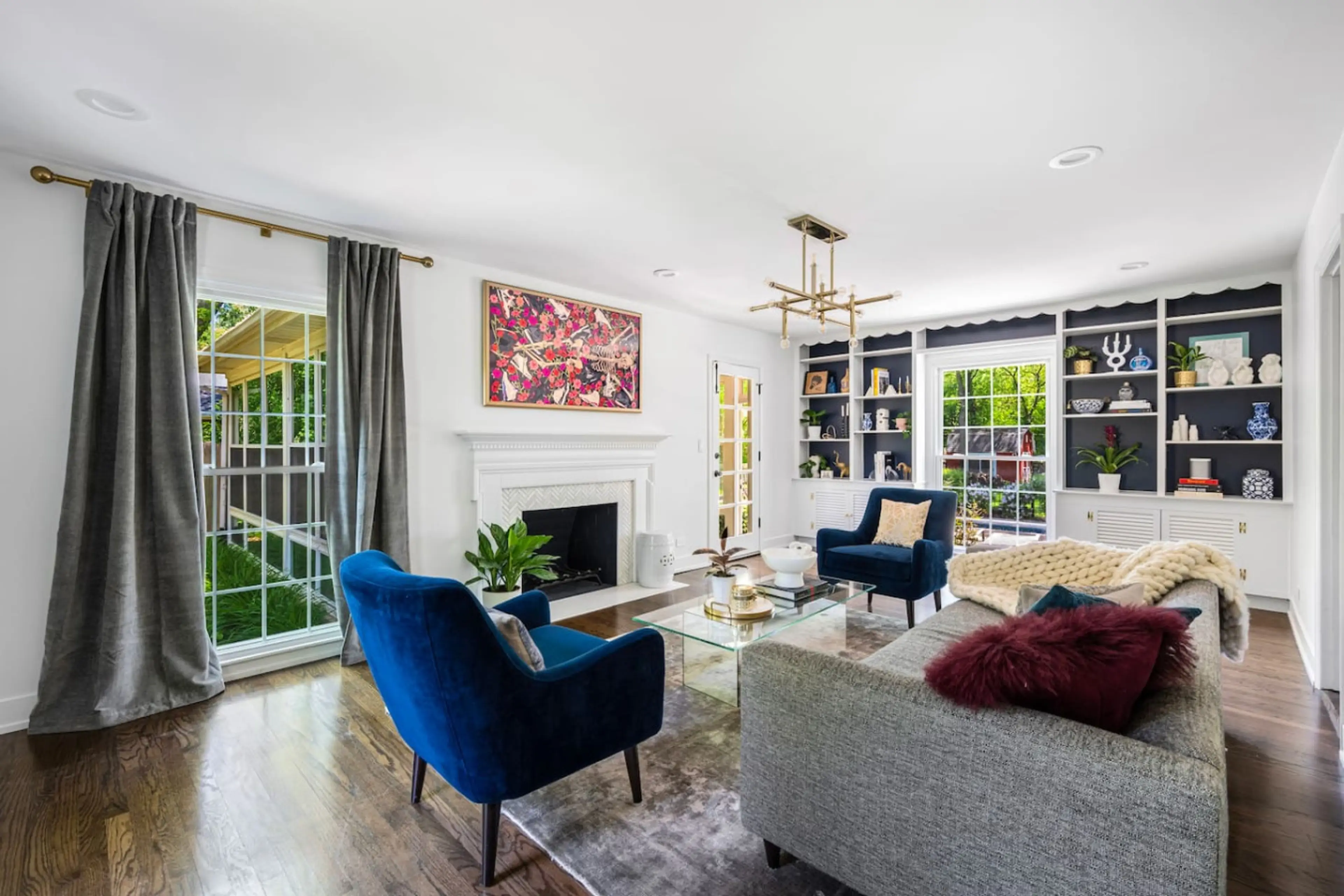 Gorgeous living room features a 65-inch Samsung Frame TV, CB2 movie sofa, two very comfortable Room & Board chairs, and beautifully designed built-in bookshelves.