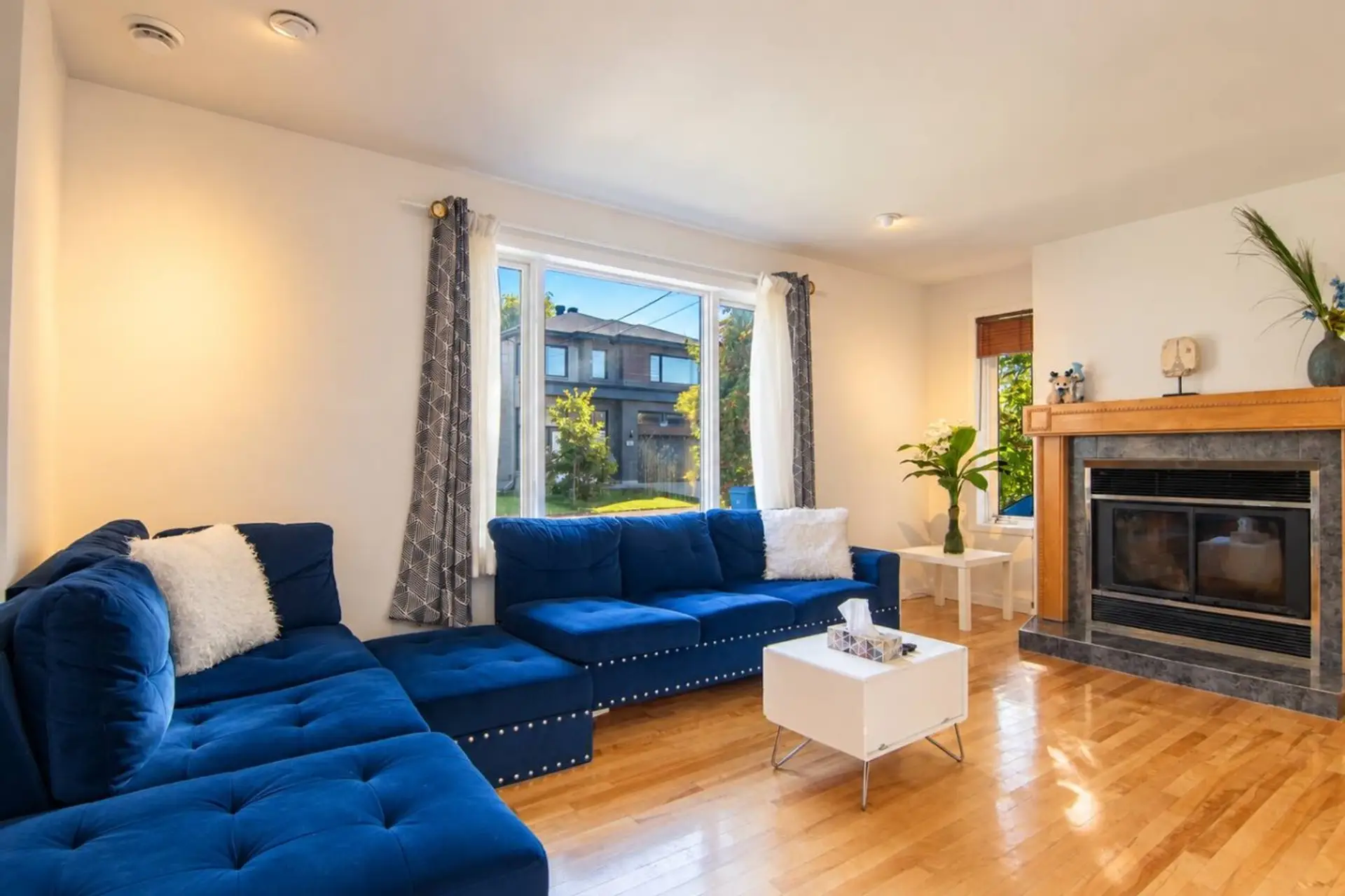 Bright living room with plush seating, fireplace and Smart TV.