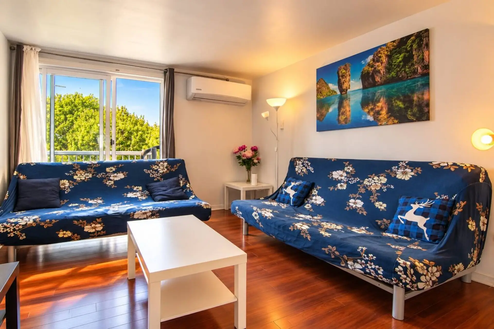 Bright lounge with two sofa beds, Smart TV and balcony access.