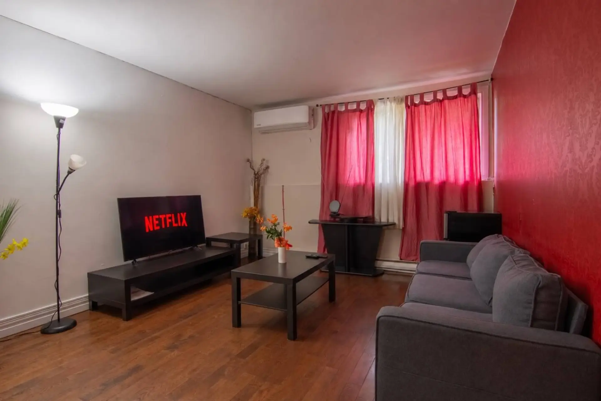Cozy living room with Smart TV, sofa and air conditioning.