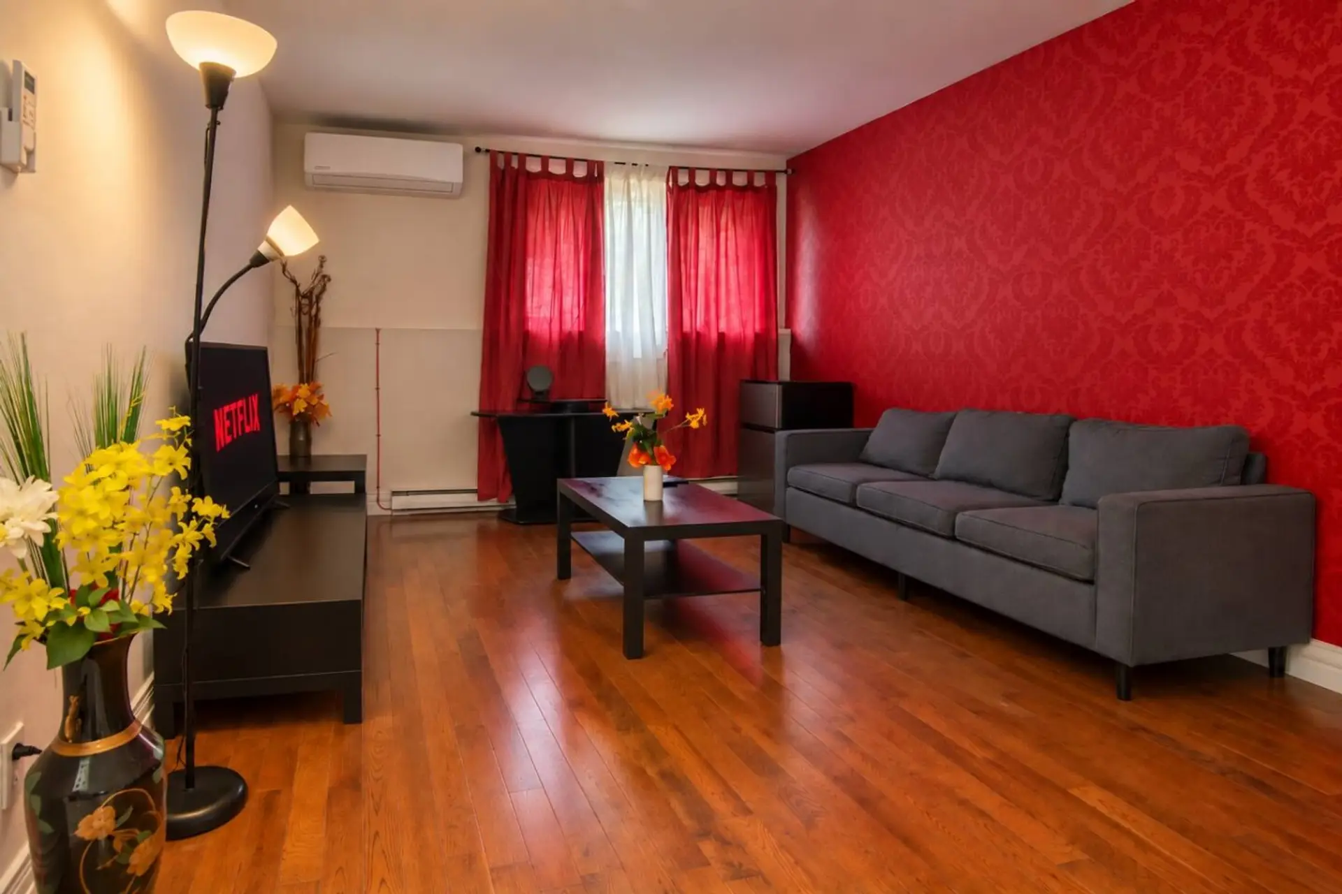 Cozy living room with Smart TV, sofa and air conditioning.
