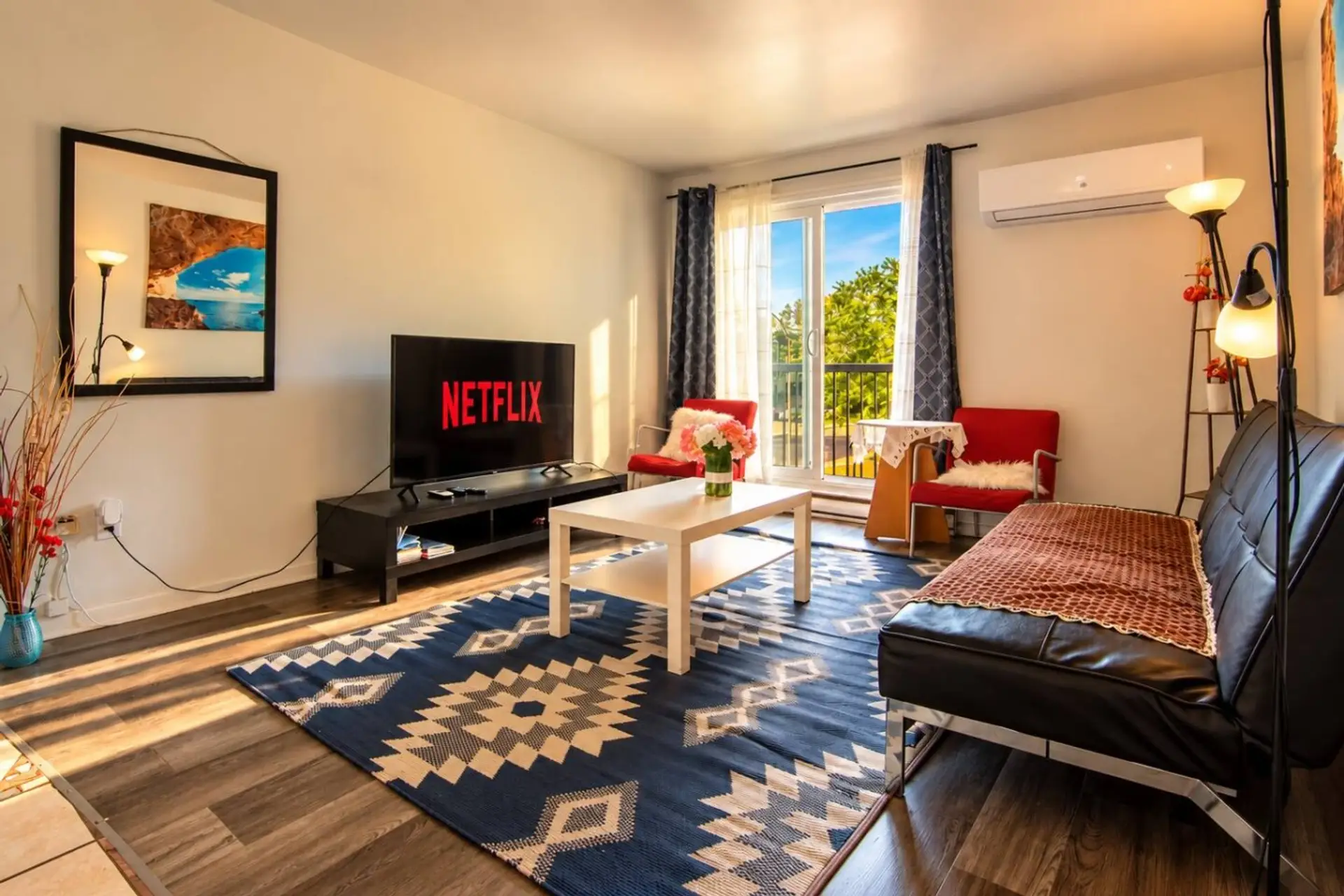 Bright living room with sofa bed, Smart TV, balcony and air conditioning.