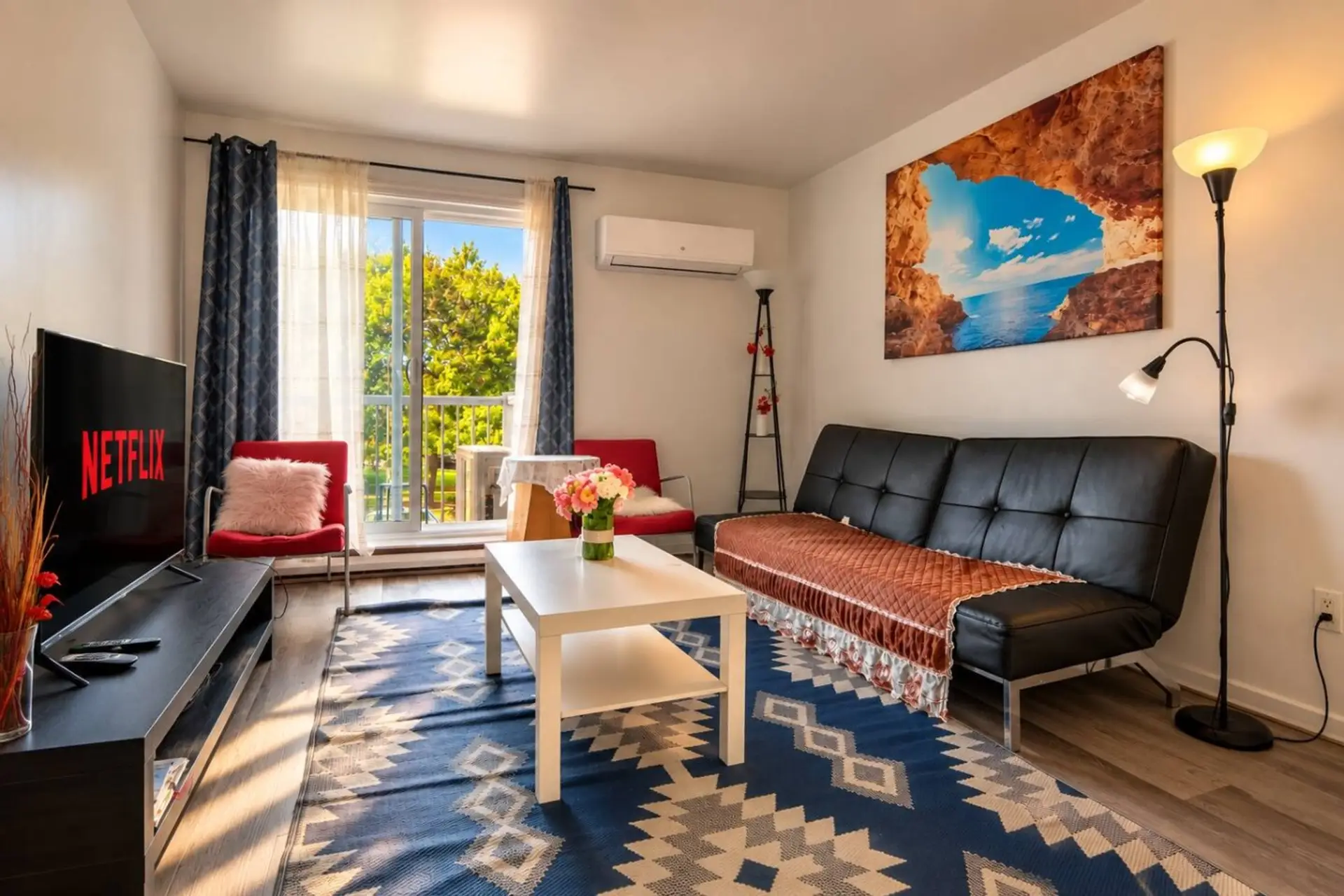 Bright living room with sofa bed, Smart TV, balcony and air conditioning.