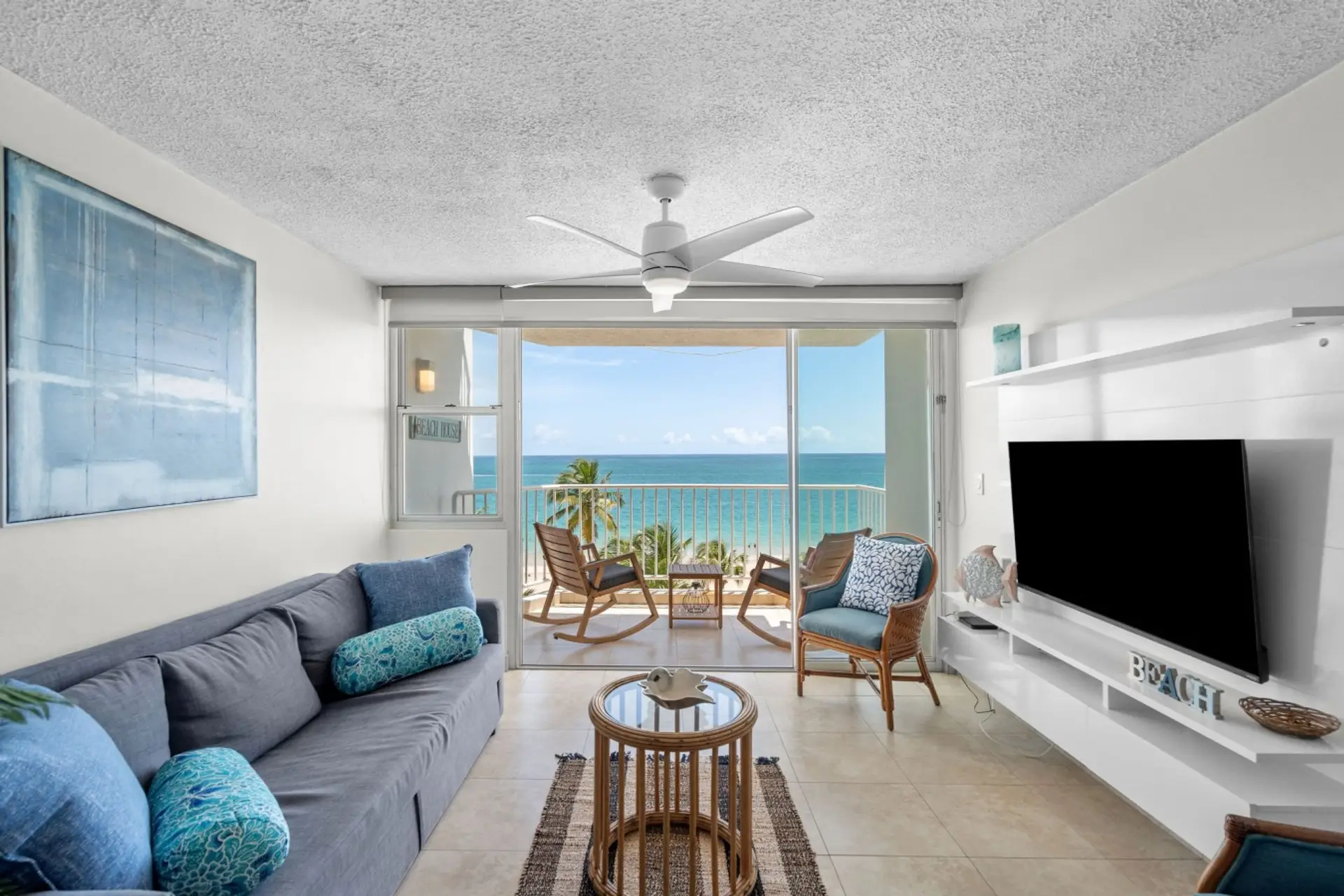 Bright oceanfront living room with sweeping views of Isla Verde Beach.