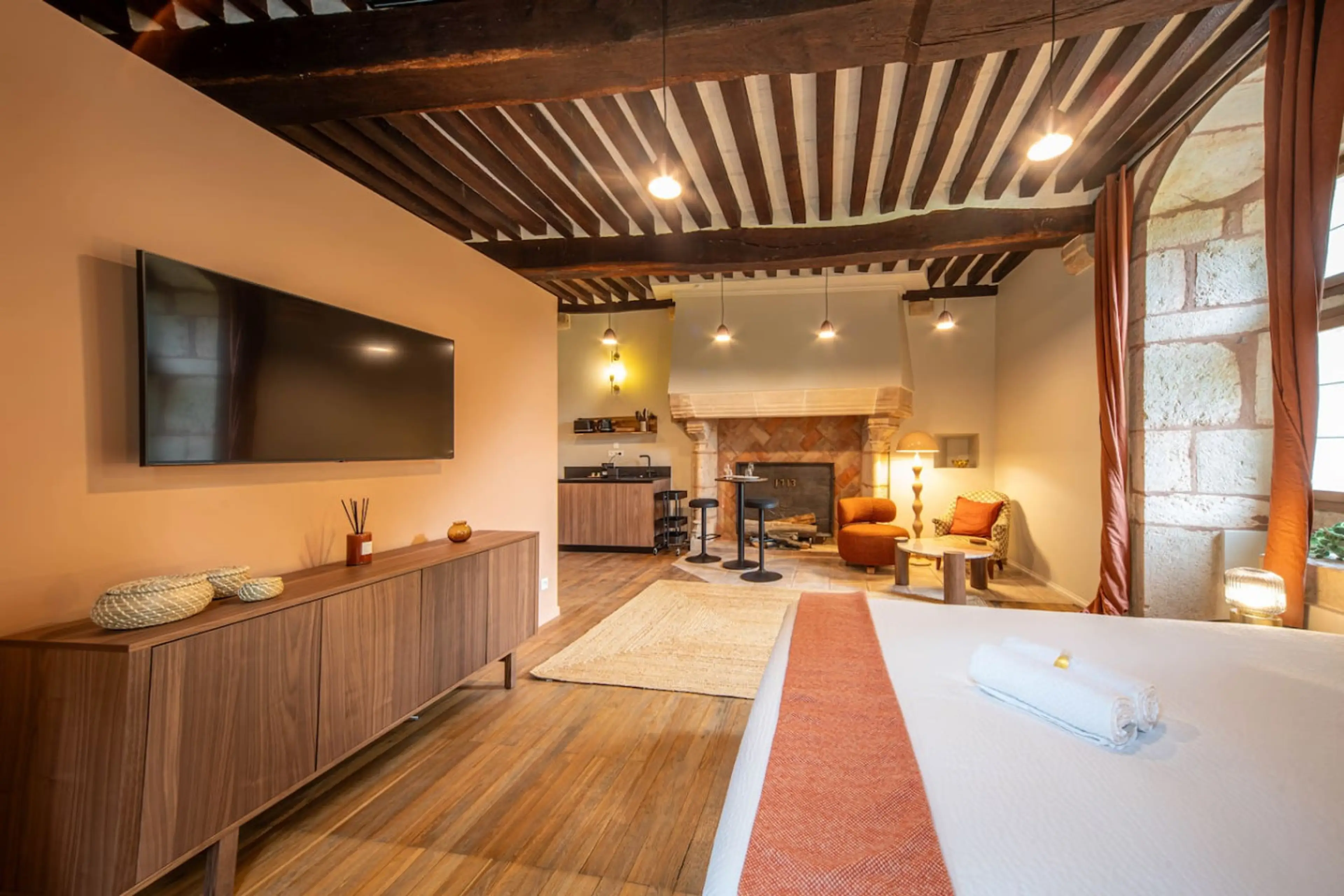 Spacieux séjour lumineux avec cuisine ouverte, foyer, TV murale et terrasse ensoleillée