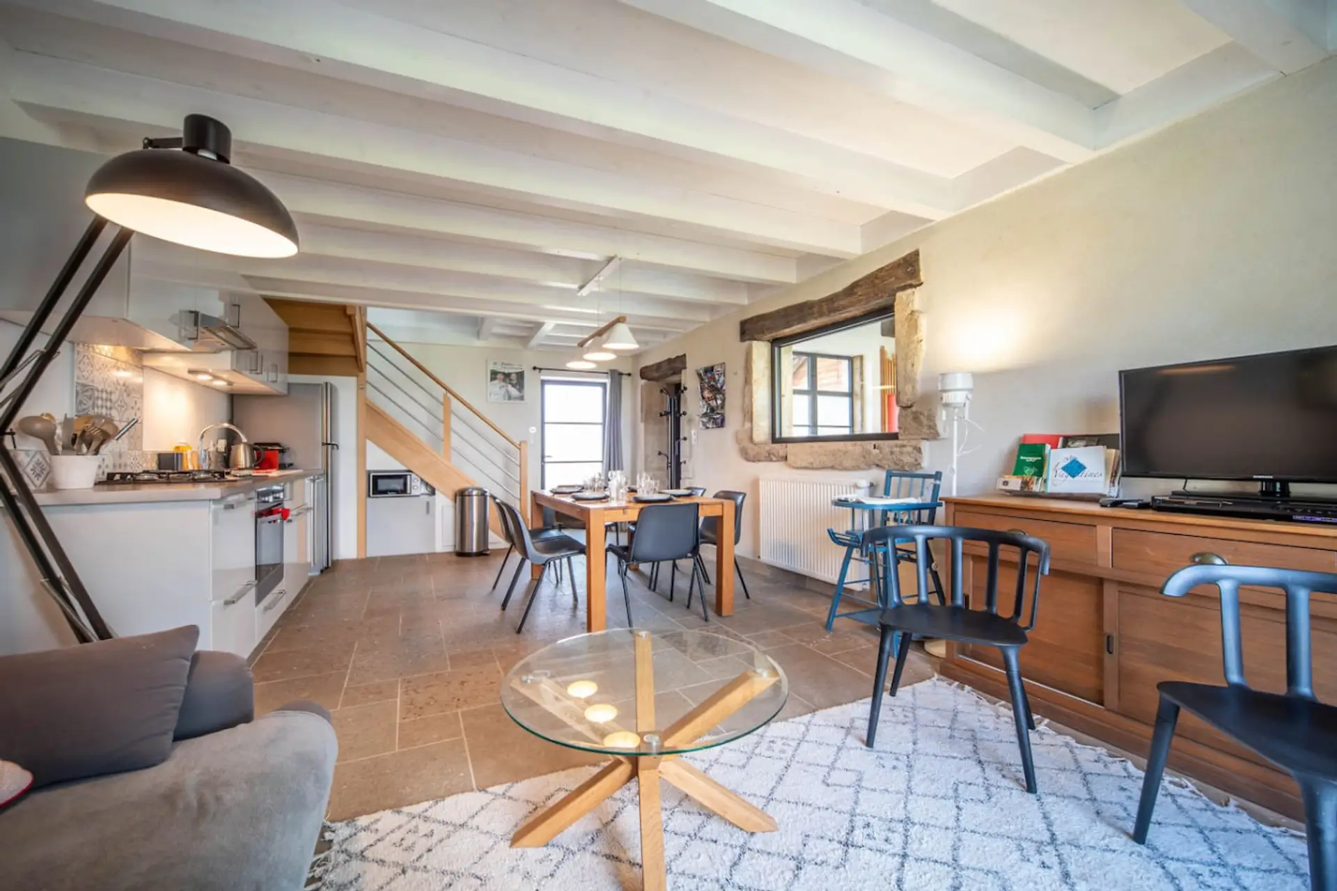 Salon spacieux et lumineux avec cuisine ouverte, coin repas convivial et équipements modernes