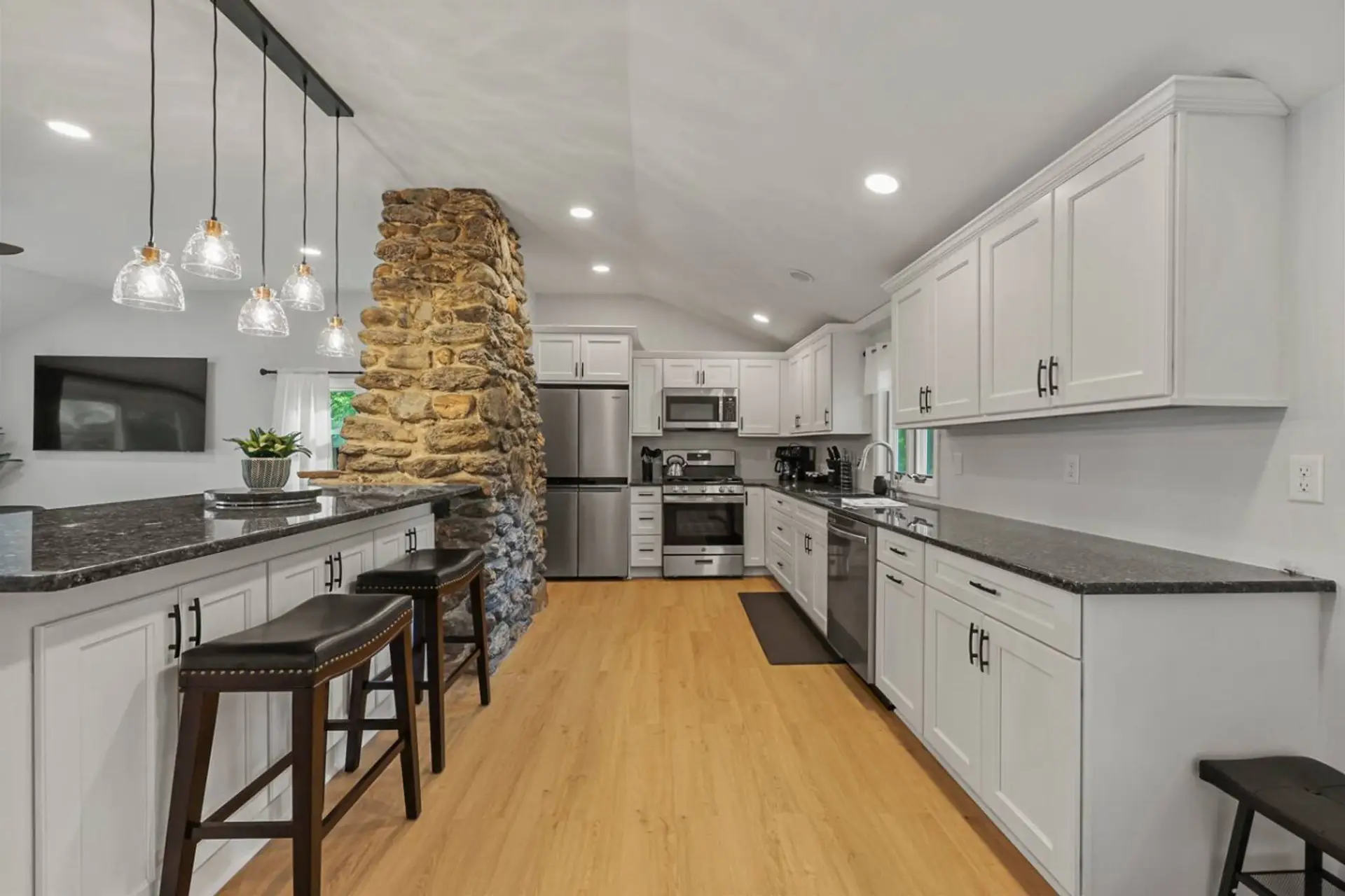 Fully equipped kitchen with stainless steel appliances, including refrigerator, oven, microwave, and dishwasher.