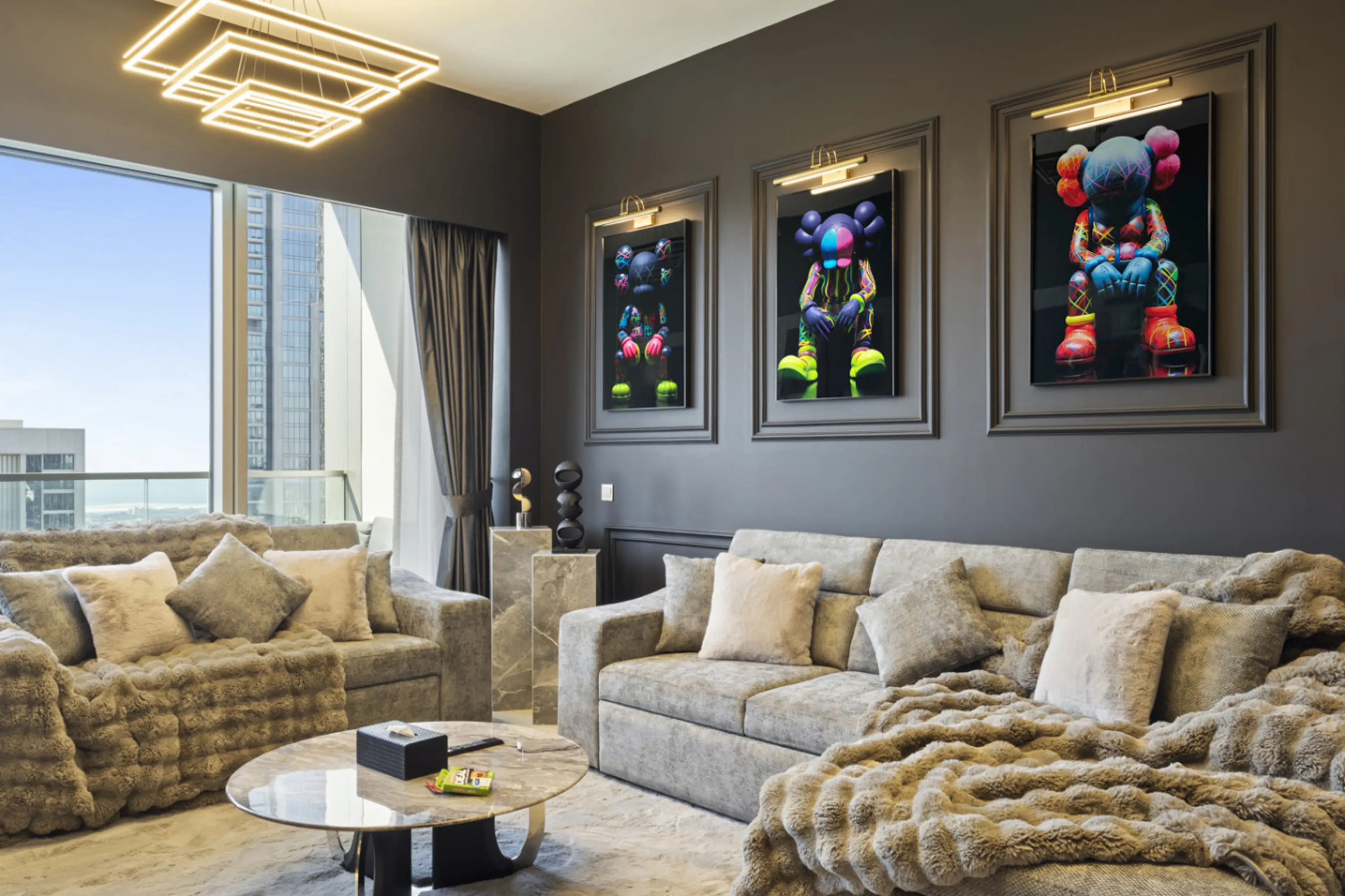 Chic living room with artistic portrait, cozy coffee table, and card games—ideal for laid-back evenings in this fully furnished, family-friendly Dubai vacation home with skyline views.