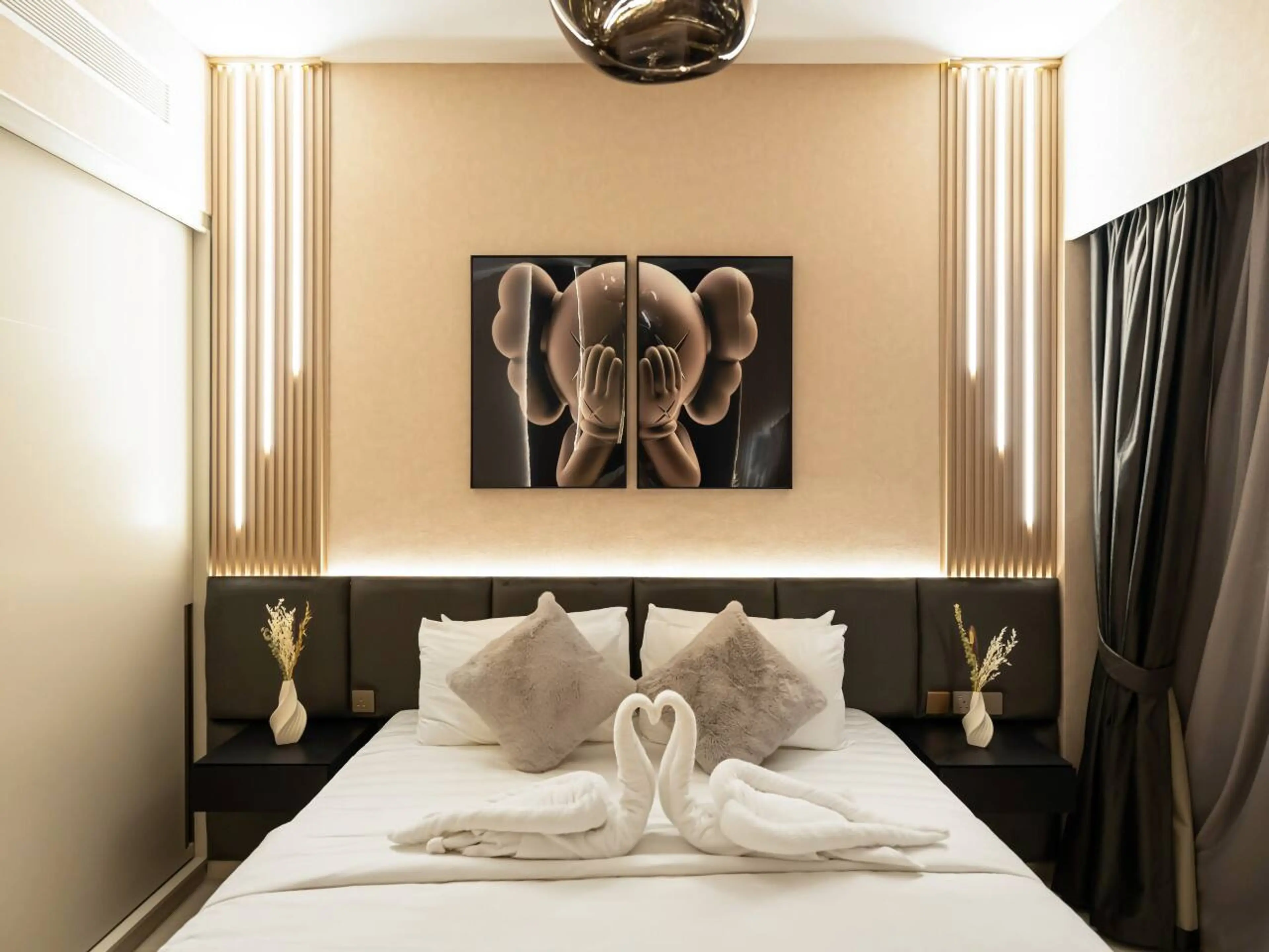 Stylish bedroom featuring a modern bed design with ambient LED lighting and distinctive Bearbricks artwork on the back wall. Experience a unique blend of luxury, comfort, and artistic flair in this upscale Downtown Dubai vacation home.