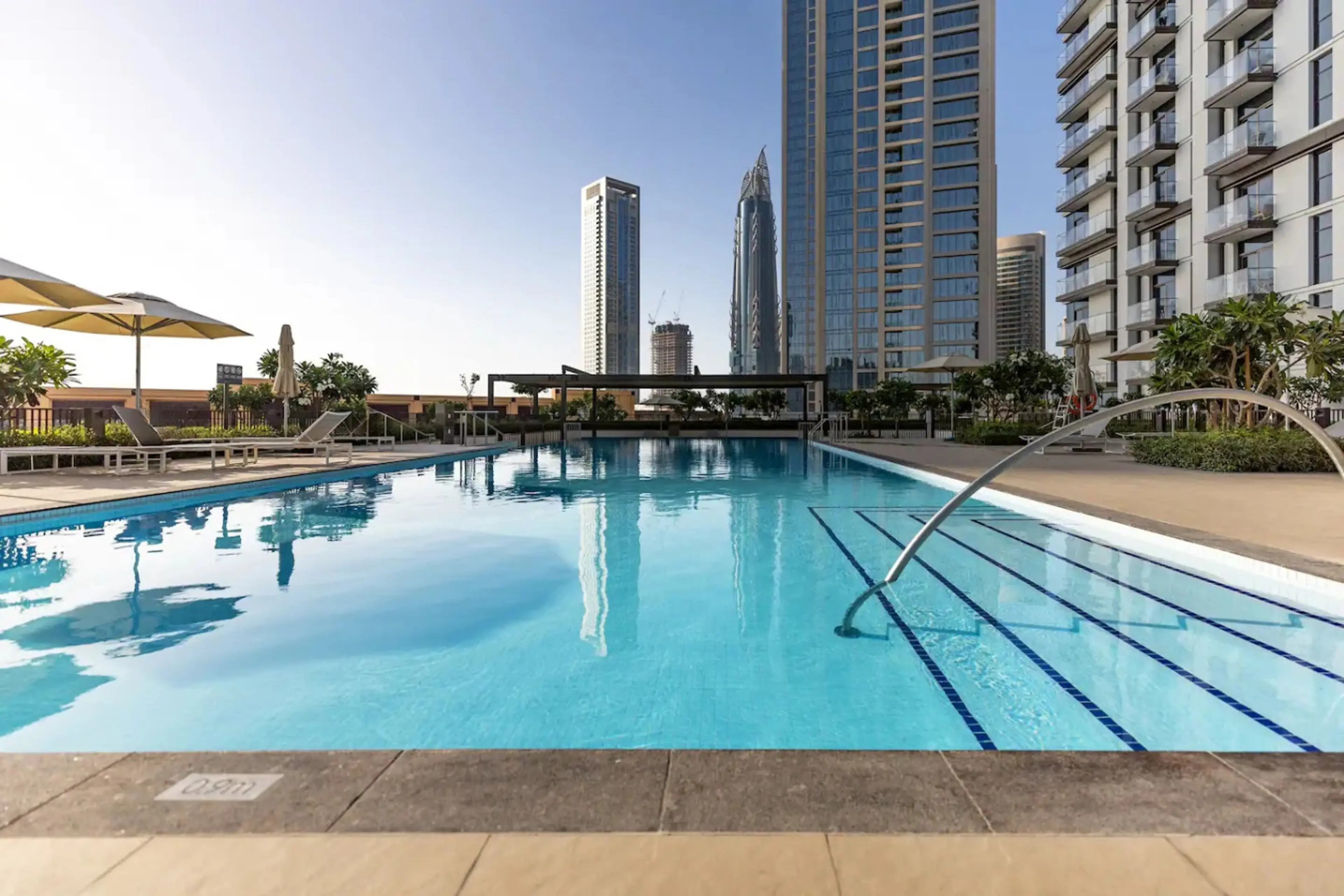 Elegant swimming pool providing a tranquil retreat for relaxation and recreation. Enjoy the refreshing ambiance and luxury amenities in this upscale Downtown Dubai vacation home, perfect for your stay.