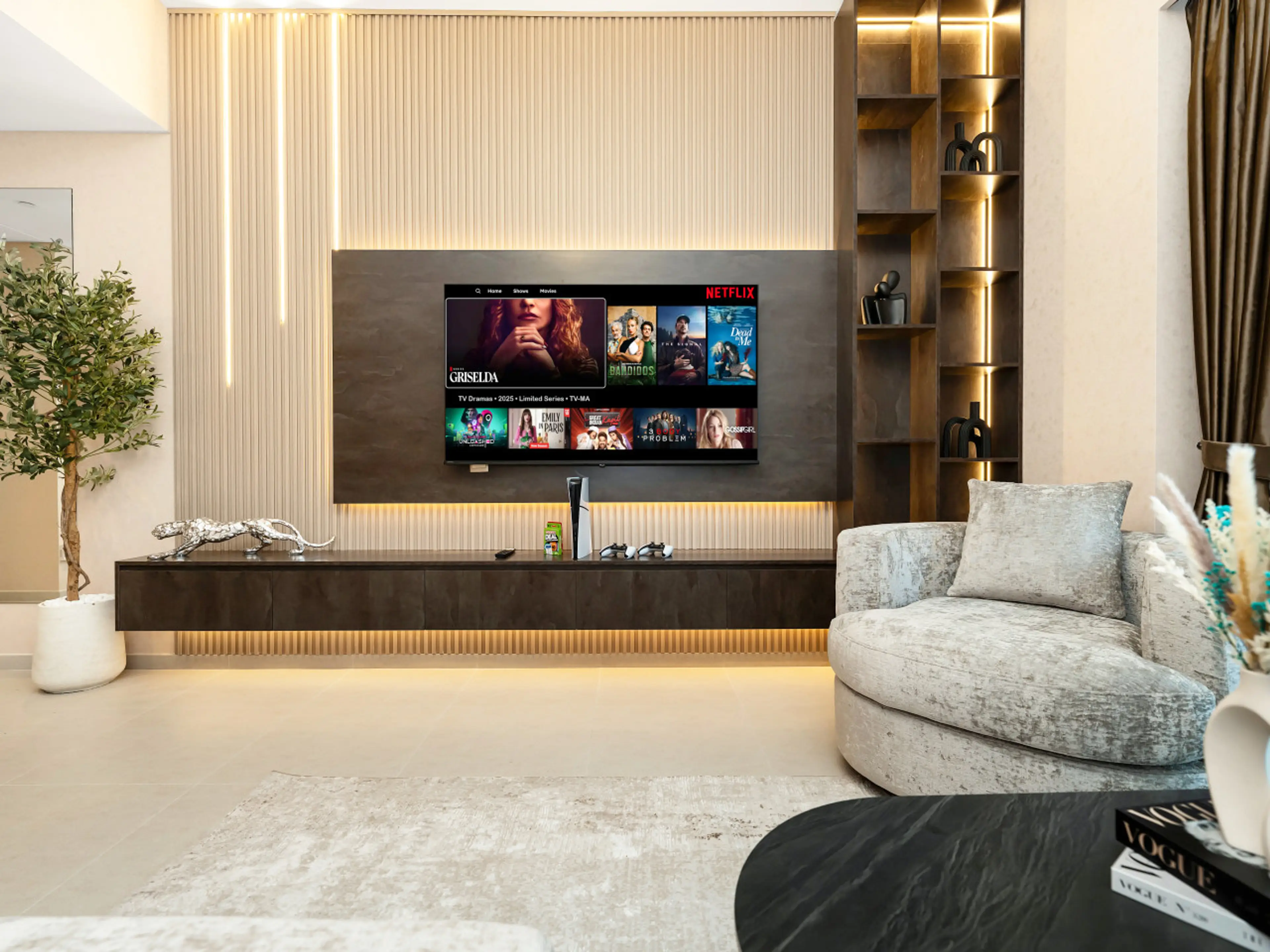 Elegant living room featuring a modern media wall, Smart TV, and cozy single-seater sofa, offering the perfect space to relax and enjoy your stay in a premium Downtown Dubai apartment.