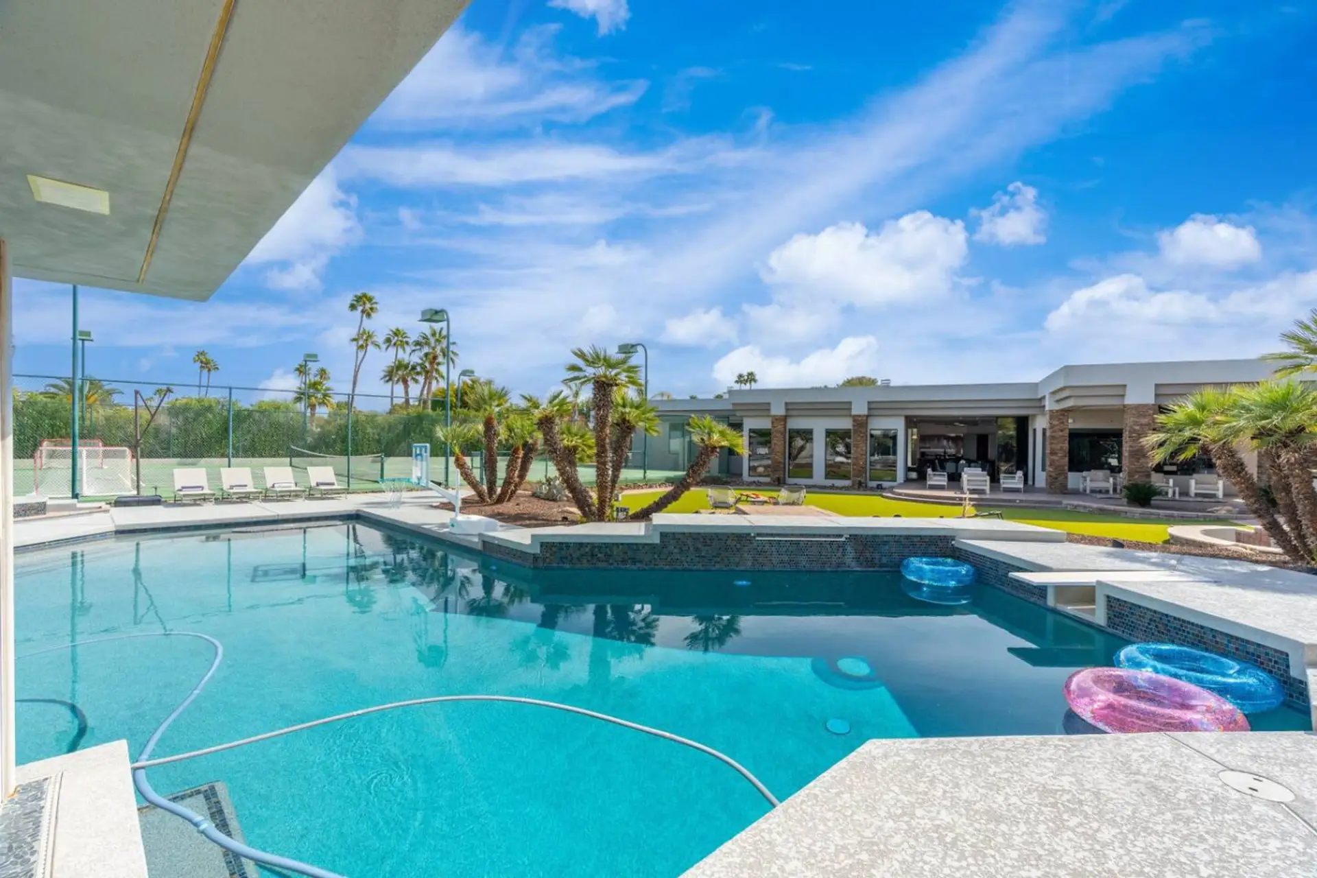 Resort-style heated pool with in-water seating, sunny lounging areas, and plenty of space to relax.